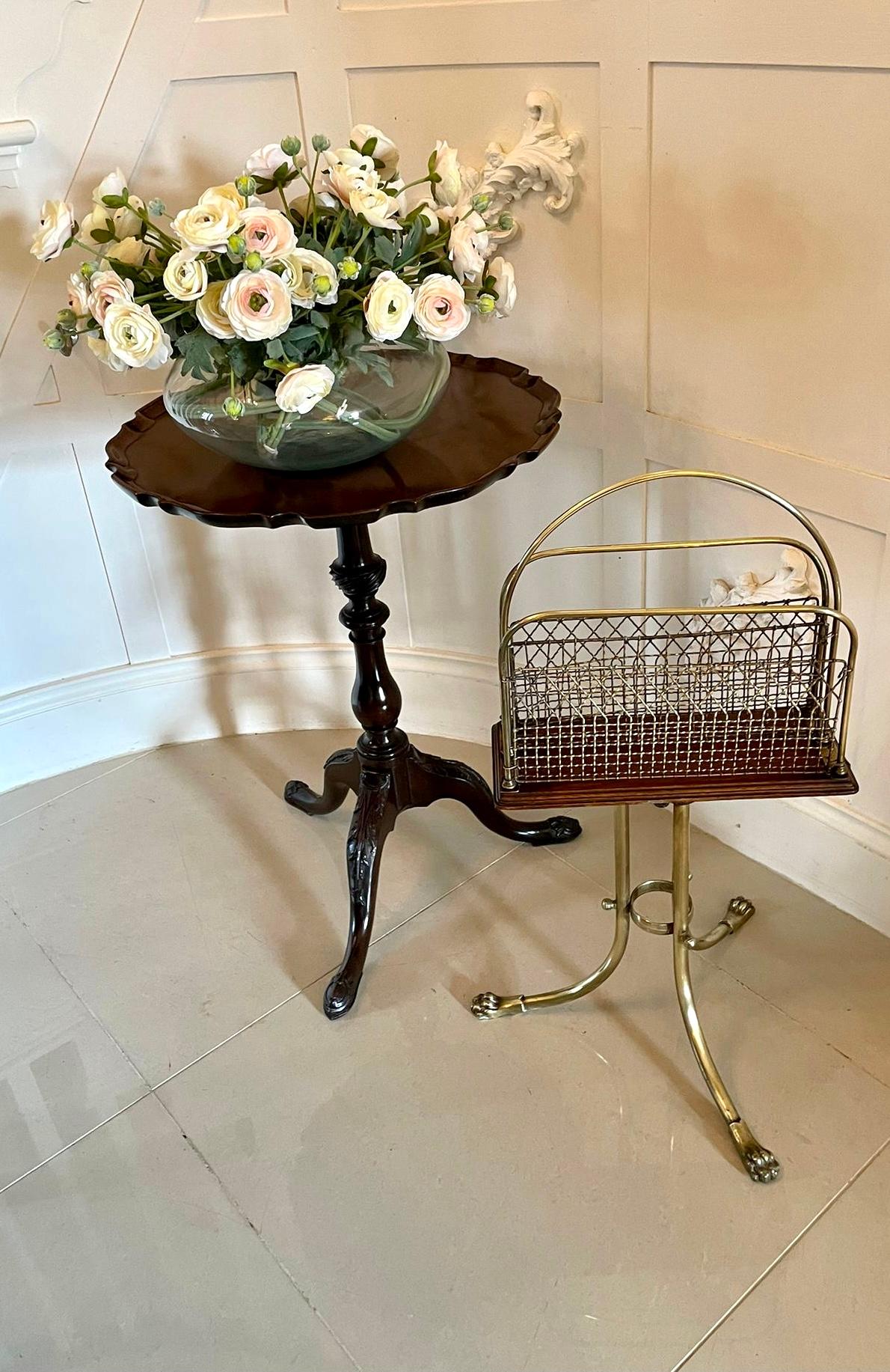 Quality antique Victorian brass and mahogany revolving magazine stand having a shaped brass handle to the centre, two sections for magazines with brass mesh wire on a mahogany revolving base with a moulded edge and supported on three shaped brass