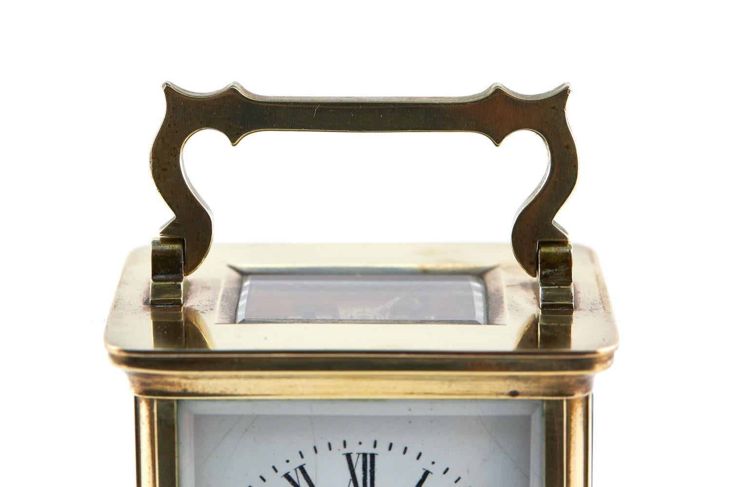 This is a quality late 19th Century Victorian antique brass carriage clock which has a quality brass and bevelled edge glass case with a white enamel dial with Roman numerals and an 8 day French movement. It comes with original key.
