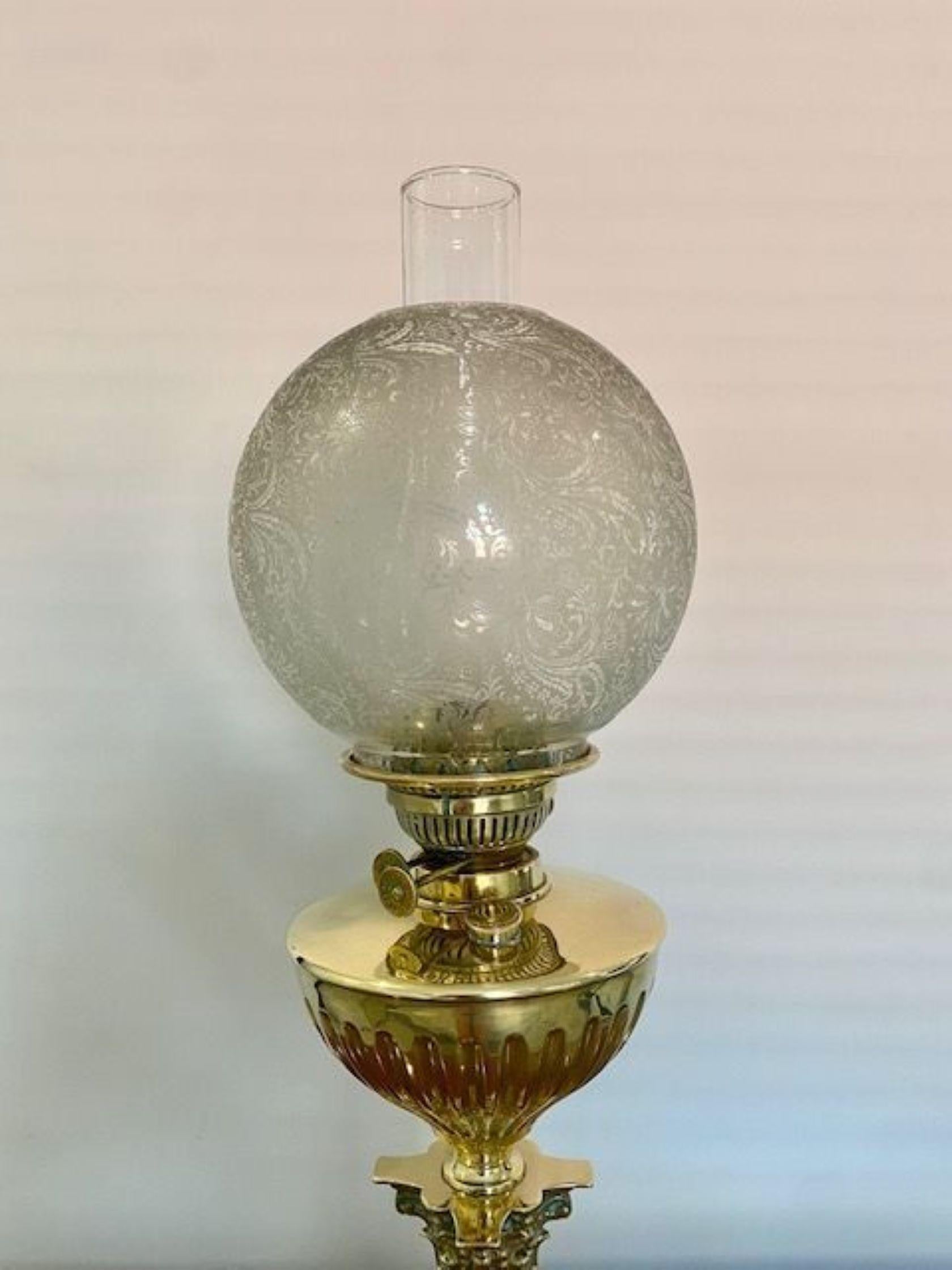 Quality antique Victorian brass oil lamp having the original floral decorated glass shade, brass reservoir supported on a brass Corinthian column raised on a square stepped brass base 