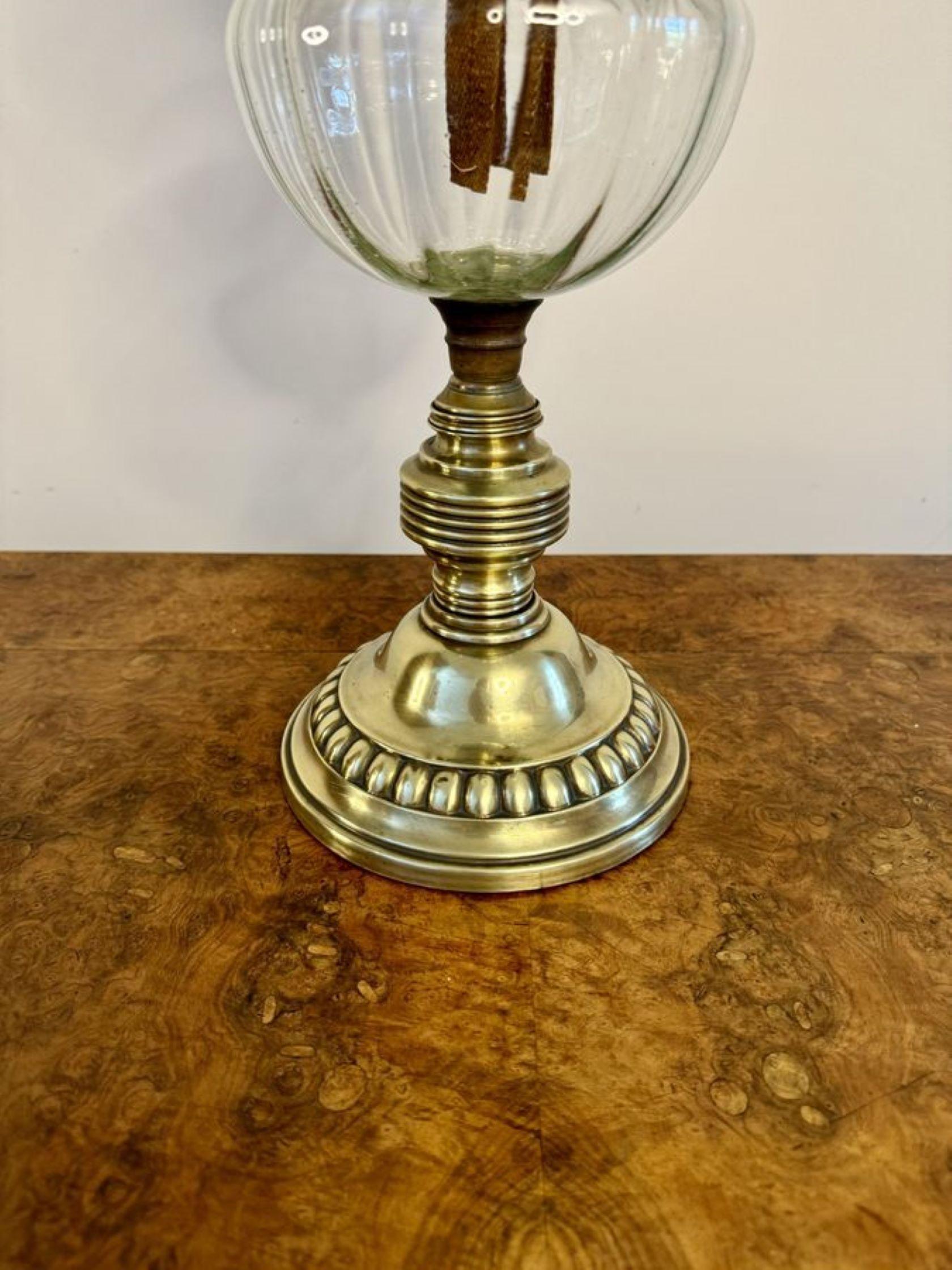 Quality antique Victorian brass oil lamp, having a quality antique Victorian brass oil lamp with an etched glass globe and a glass chimney above a double brass burner and clear glass reservoir, raised on a brass column with a circular ornate brass