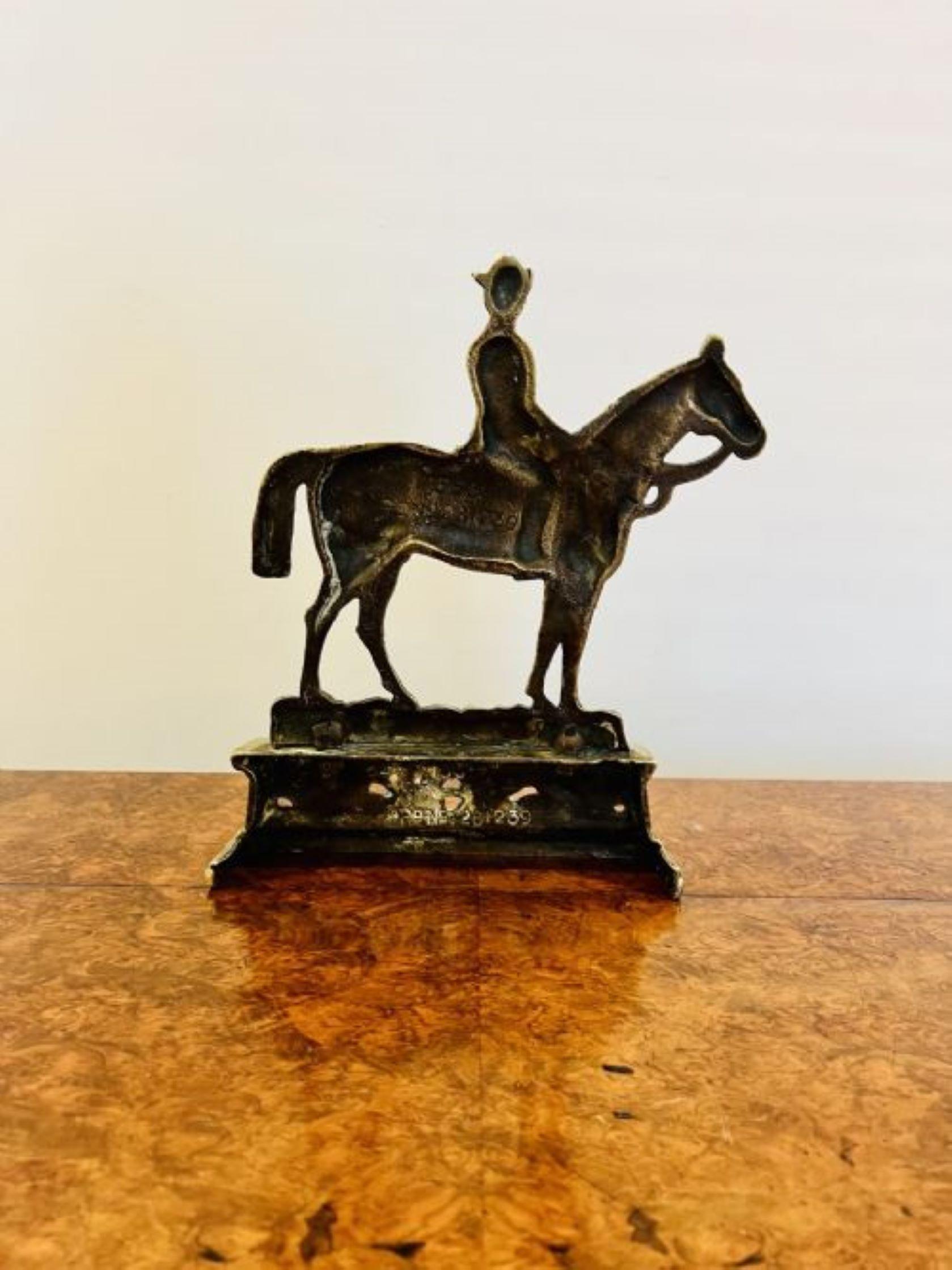 Quality antique brass ornate 'Dr Jim' doorstop having a modelled figure on horseback above a crossed spear and scroll decorated brass base 