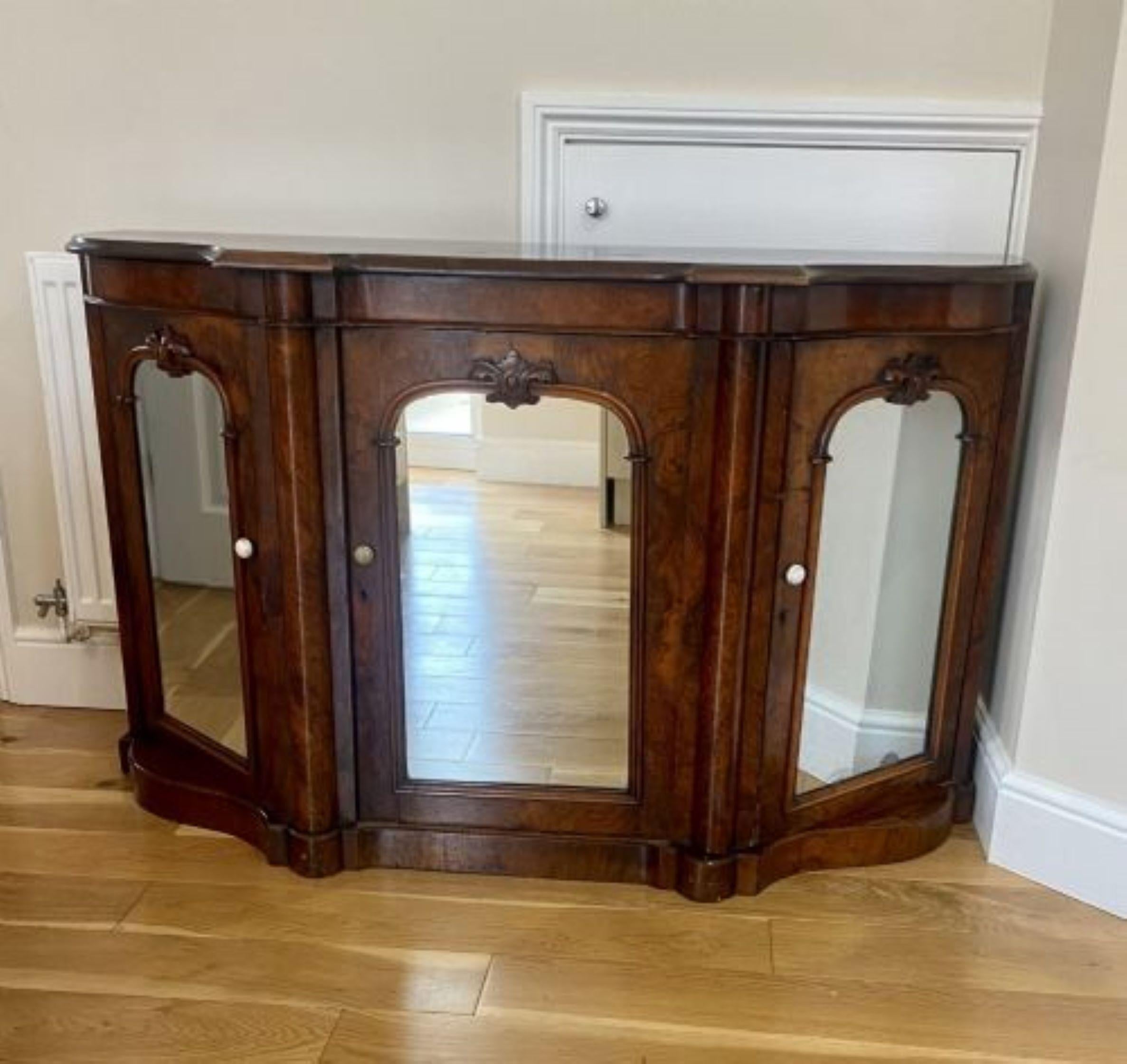 Quality antique Victorian burr walnut mirrored credenza having a shaped top with a thumb moulded edge above a shaped burr walnut freeze, three burr walnut carved doors with original mirrors opening to reveal fitted shelf interiors, standing on a