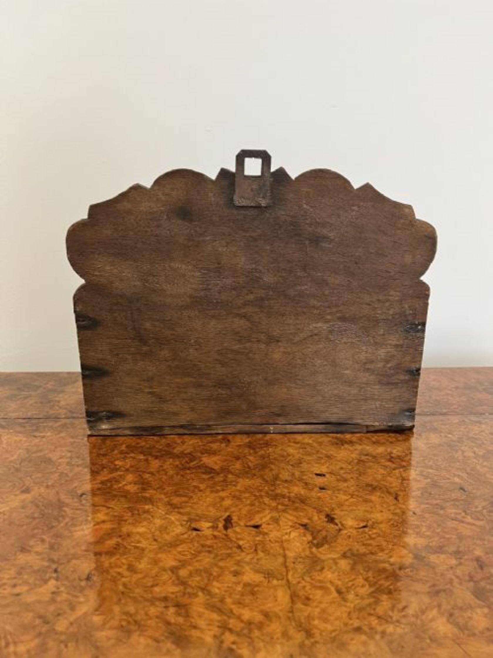 Quality antique Victorian carved oak candle box having a quality carved oak candle box carved in relief with shields and shaped crests having a carved sloping lid opening to reveal a storage compartment 