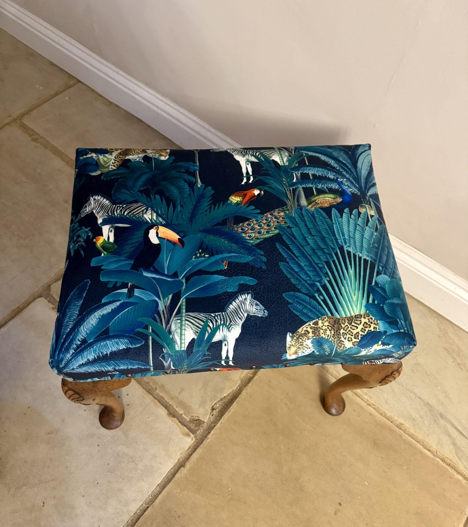Tabouret de qualité en noyer sculpté de l'époque victorienne. Le siège est tapissé de beaux motifs vibrants représentant des arbres verts, des lions, des zèbres et des pélicans. Il repose sur quatre pieds cabriole en noyer sculpté avec des détails