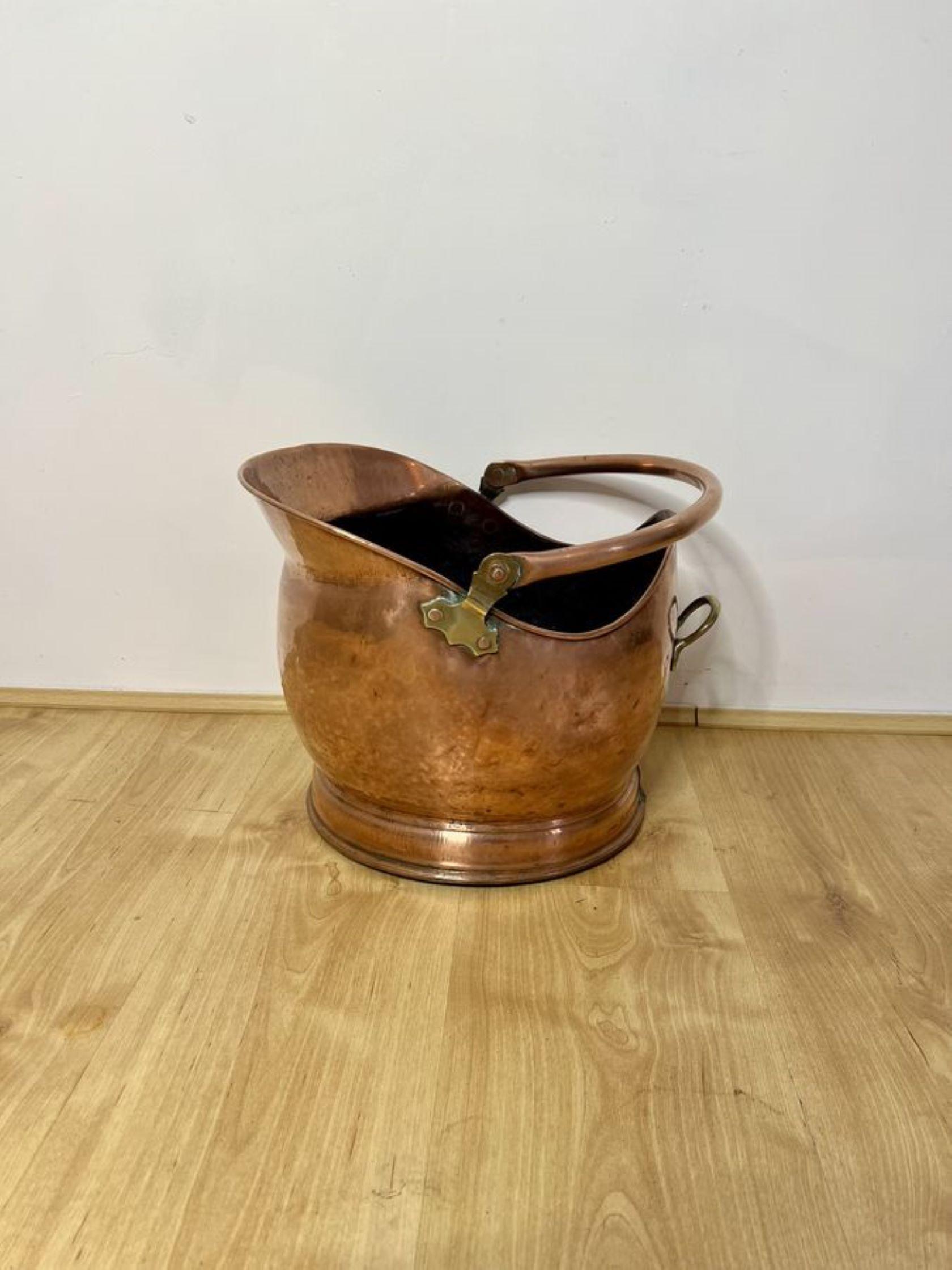 Quality antique Victorian copper helmet coal scuttle having a swing carrying handle to the top with a shaped quality copper helmet coal scuttle and a brass handle to the back.

D. 1880