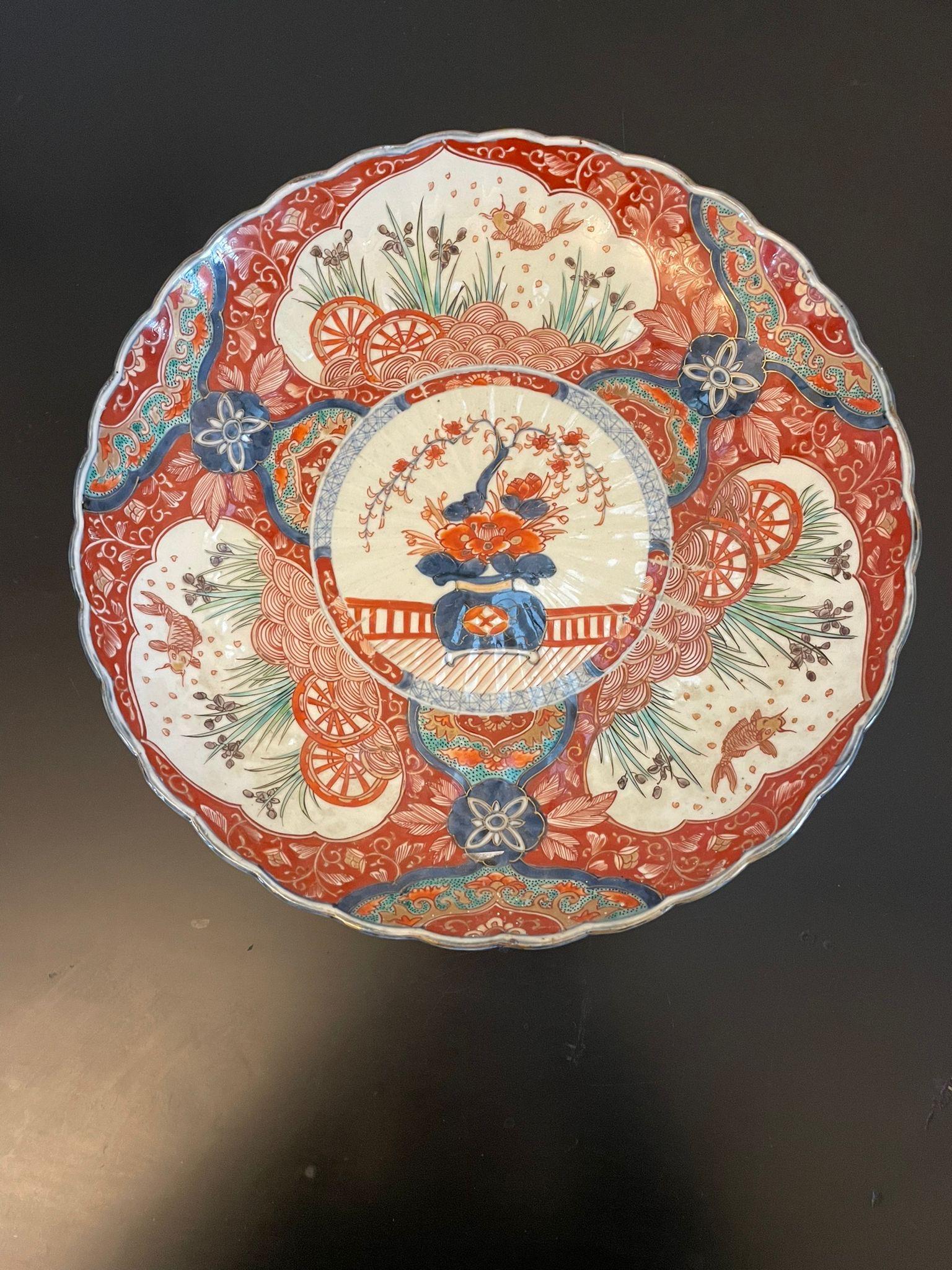 Quality antique Victorian Japanese Imari plate having fantastic hand painted panels of carp swinging in red, blue, green, orange, white and gold colours with a scalloped shaped edge 


In lovely original condition


Dimensions:
Height 5.5 cm