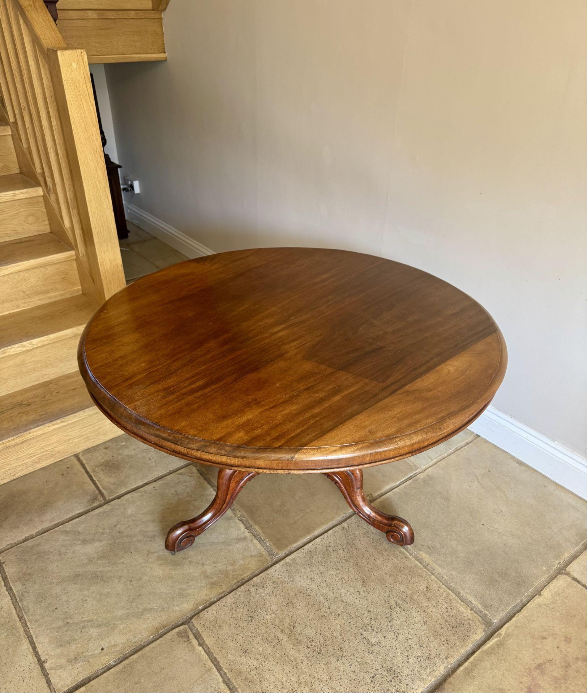 Table de salle à manger circulaire en acajou de qualité, de style victorien ancien, avec une frise en acajou soutenue par un piédestal tourné reposant sur trois pieds à volutes sculptés et les roulettes d'origine.

D. 1880
