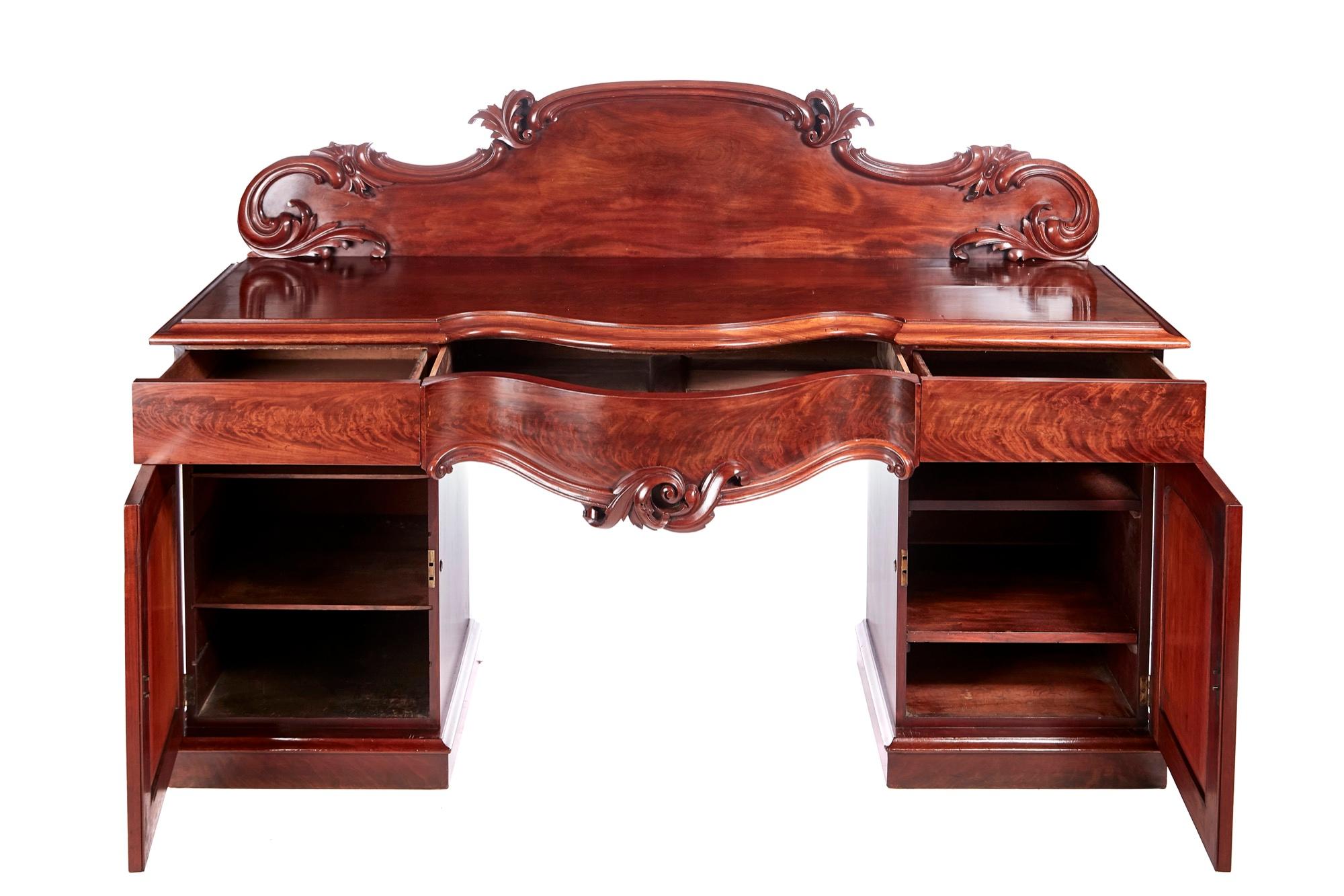 Quality antique Victorian mahogany sideboard having lovely shaped carved back, super quality mahogany serpentine shaped top with a molded edge, 3 frieze drawers, 2 cupboard doors with molded panels, fitted interior standing on a plinth