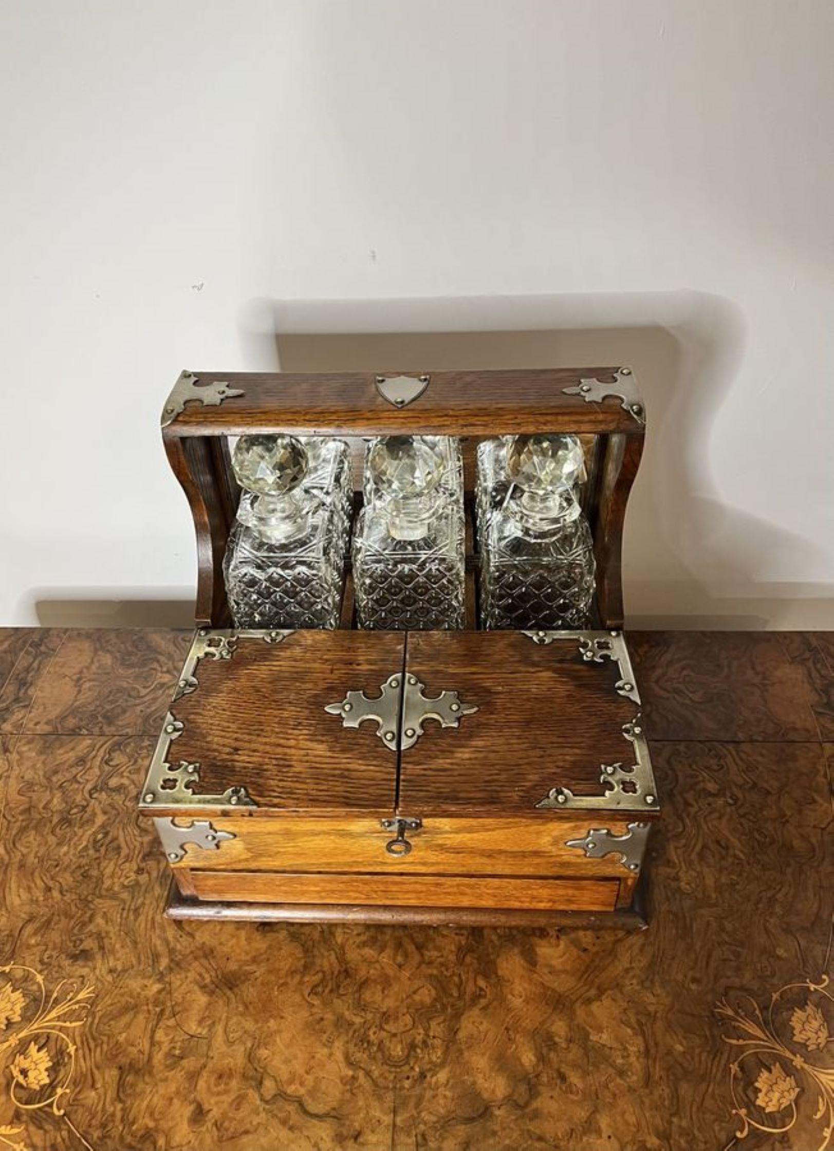 Quality antique Victorian oak tantalus and games box, having a quality oak tantalus with silvered metal mounts, carrying handles to the sides, mirror back and a compartment with three square cut glass decanters. Working lock and key with a