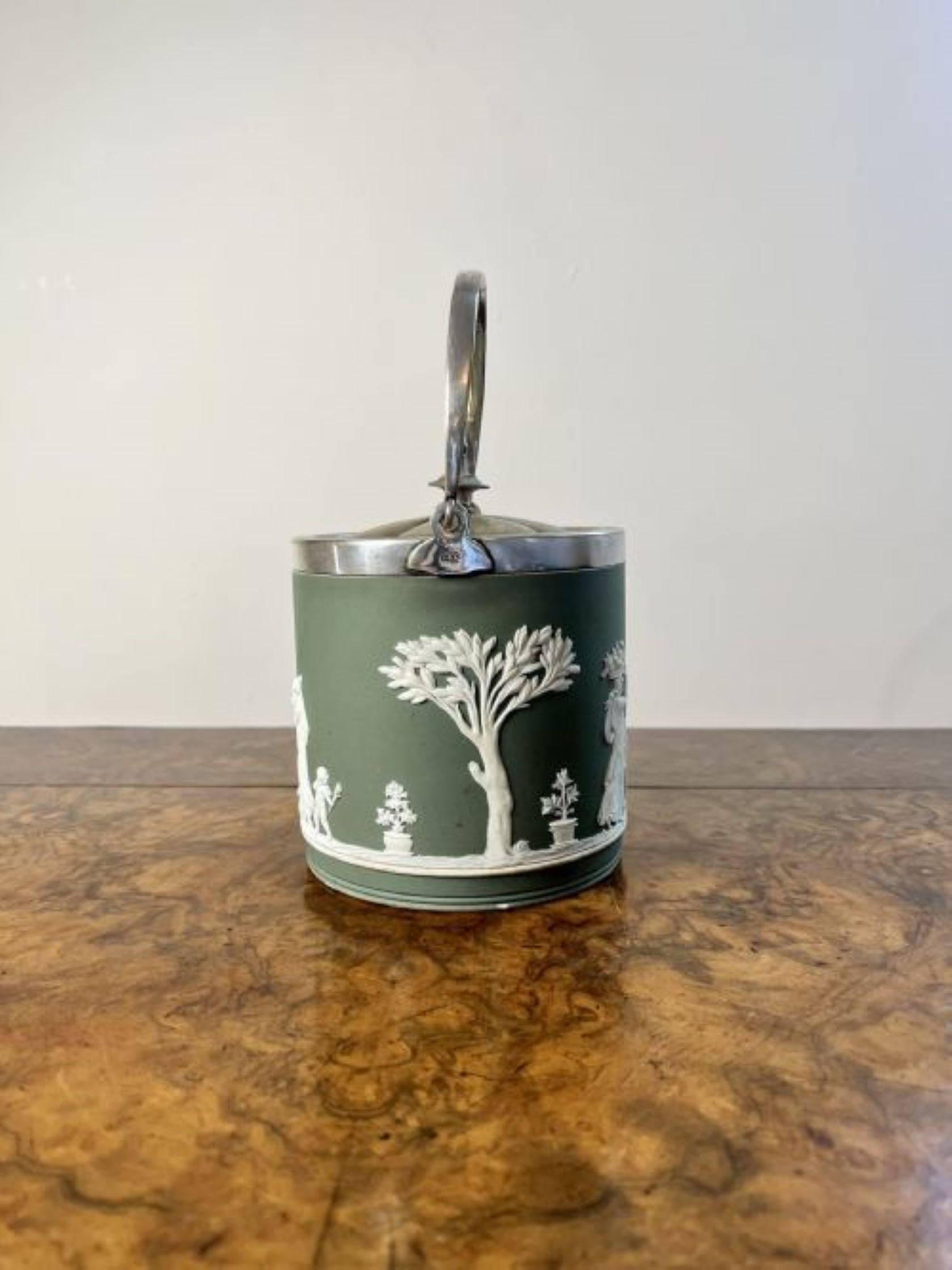 Quality antique Wedgwood Jasper Ware biscuit barrel decorated with classical scenes in a white cameo and green background with a silver plated swing handle to the top and a removable lid. 