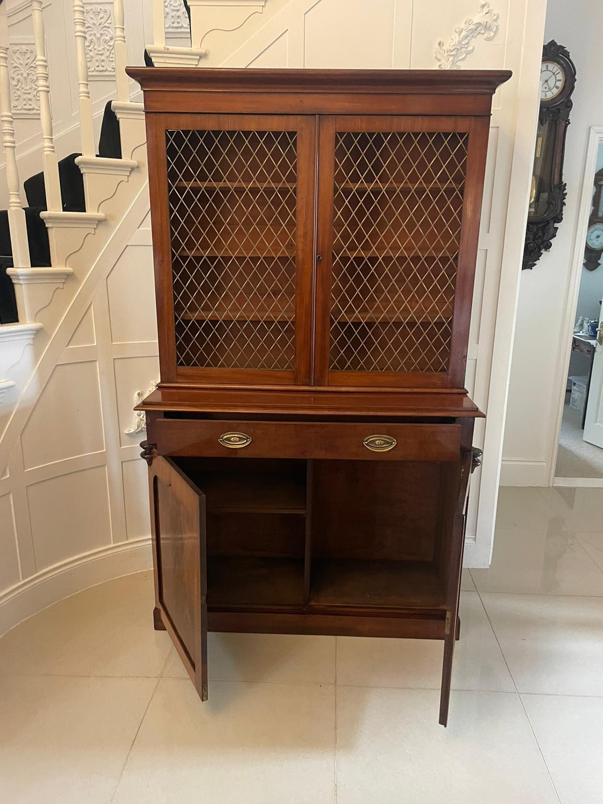 Quality antique William IV mahogany bookcase having a shaped cornice to the upper section over a pair of mahogany doors with brass grilles opening to reveal an interior with three adjustable shelves The base having one long drawer with brass handles