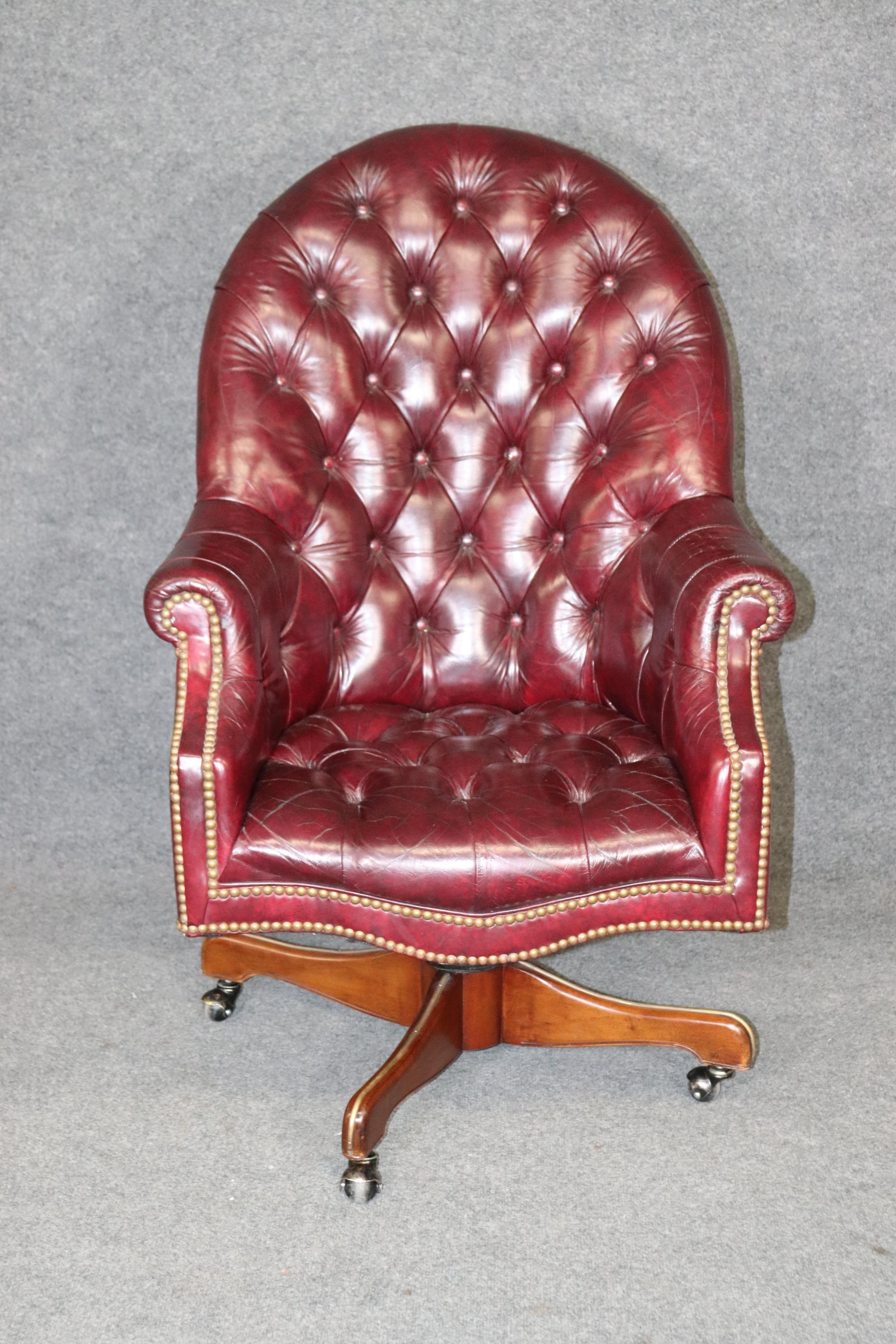This is a gorgeous burgundy leather vintage 1970s era Chesterfield style office chair that swivels. The leather is in good but used condition so it will show signs of age and wear, creases and areas around the arms with wear. The chair is in