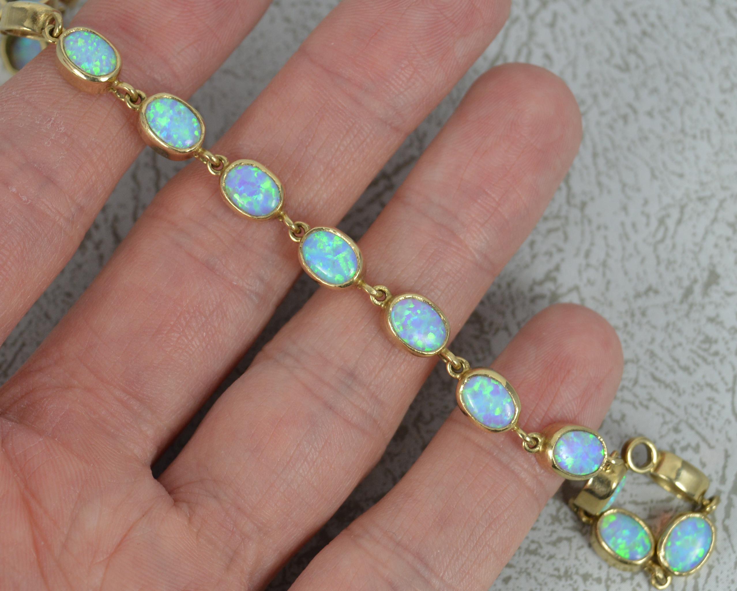 A superb 9 carat gold and opal bracelet.
Solid 9 carat yellow gold example.
Designed with sixteen very colourful opalite oval shaped stones in bezel settings.

Condition ; Excellent. Working clasp. Clean links. Issue free. Please view