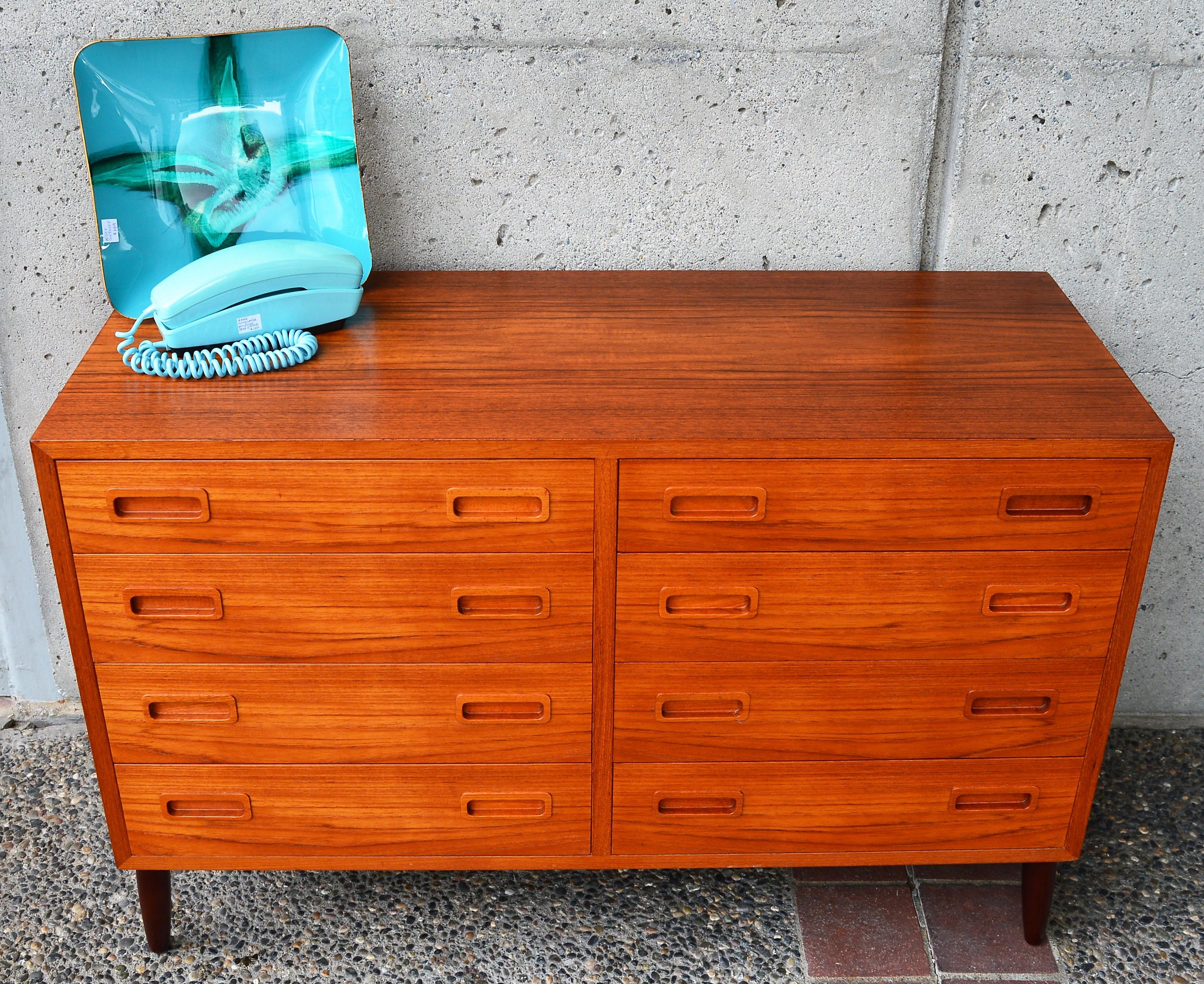 This lovely quality all hardwood Danish Modern teak compact dresser by Hundevad & Co. bears the Danish quality control medallion, as well as the branded makers mark. Clean, simple lines with 8 drawers, all with ovoid inset drawer pulls, and beech