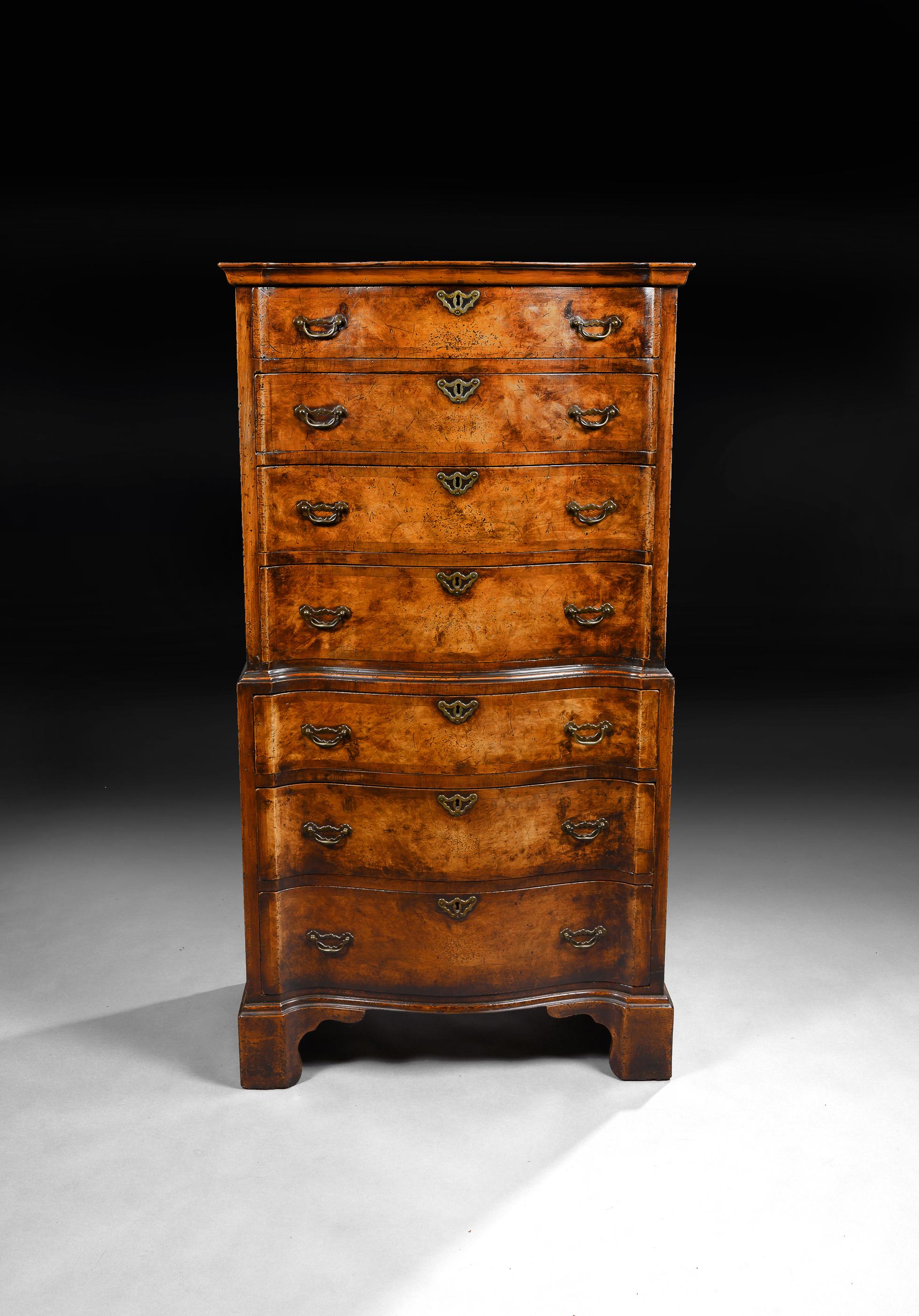 A very good quality serpentine shaped front walnut chest on chest.

English, circa 1920.

The outswept cornice above four graduated cross banded serpentine drawers with oak lined handcut dovetails, brass open back ‘bat wing’ handles and