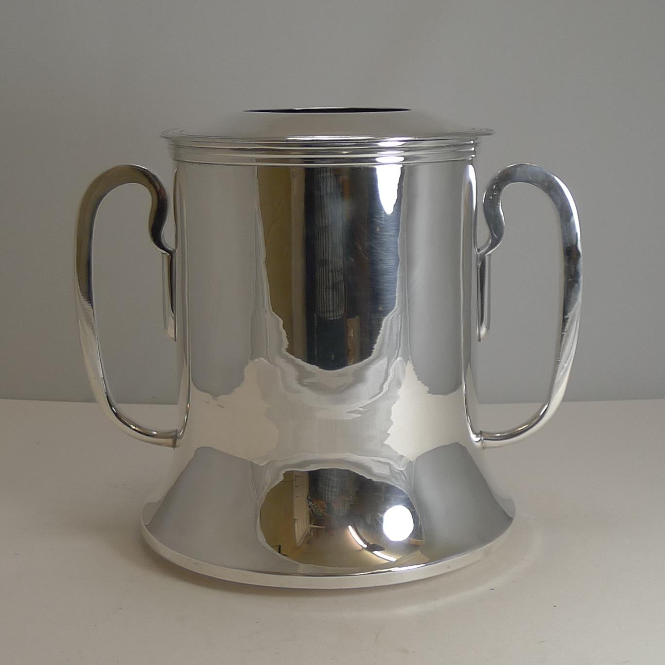 A great quality example and a smart look to impress. This stylish antique silver plated Champagne or wine cooler has been overhauled by our silversmith to create a piece ready to serve for the next 100 years.

Flanked by two large handles with an