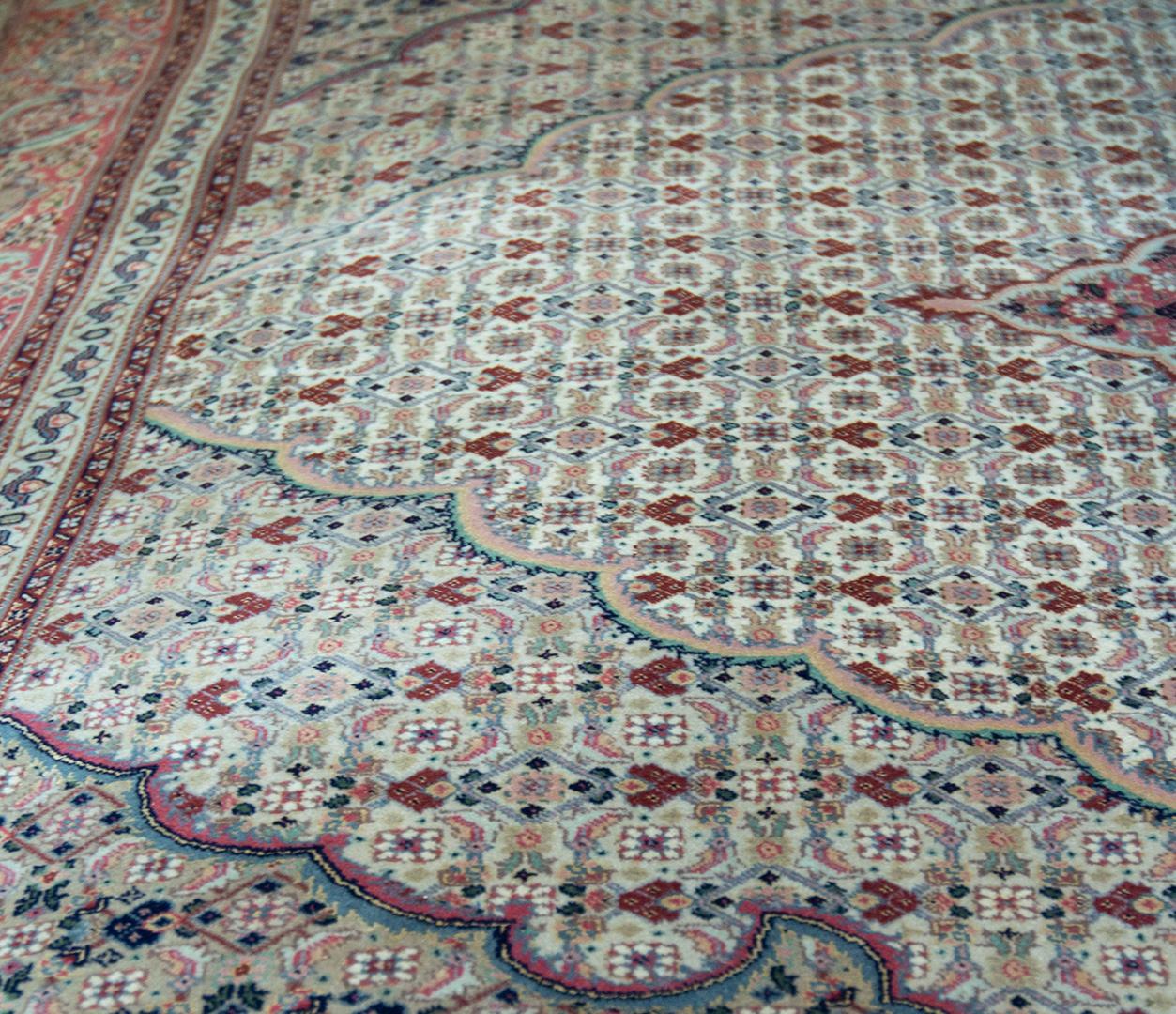 
Dieser Vintage-Teppich aus Täbriz (um 1970) hat ein elfenbeinfarbenes Feld mit einem dichten rostroten und schattierten buff-braunen und blauen Herati-Muster um ein zentrales, ähnlich schattiertes rotes und elfenbeinfarbenes Medaillon mit