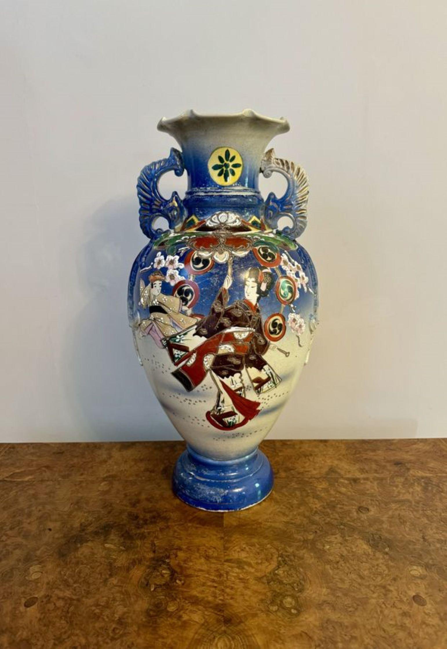 Gran jarrón satsuma japonés antiguo de calidad, con fondo azul y blanco decorado con flores, figuras y dibujos en vivos colores rojo, verde, amarillo y dorado, con asas gemelas a los lados del cuello acanalado y parte superior ondulada. 

D. 1900