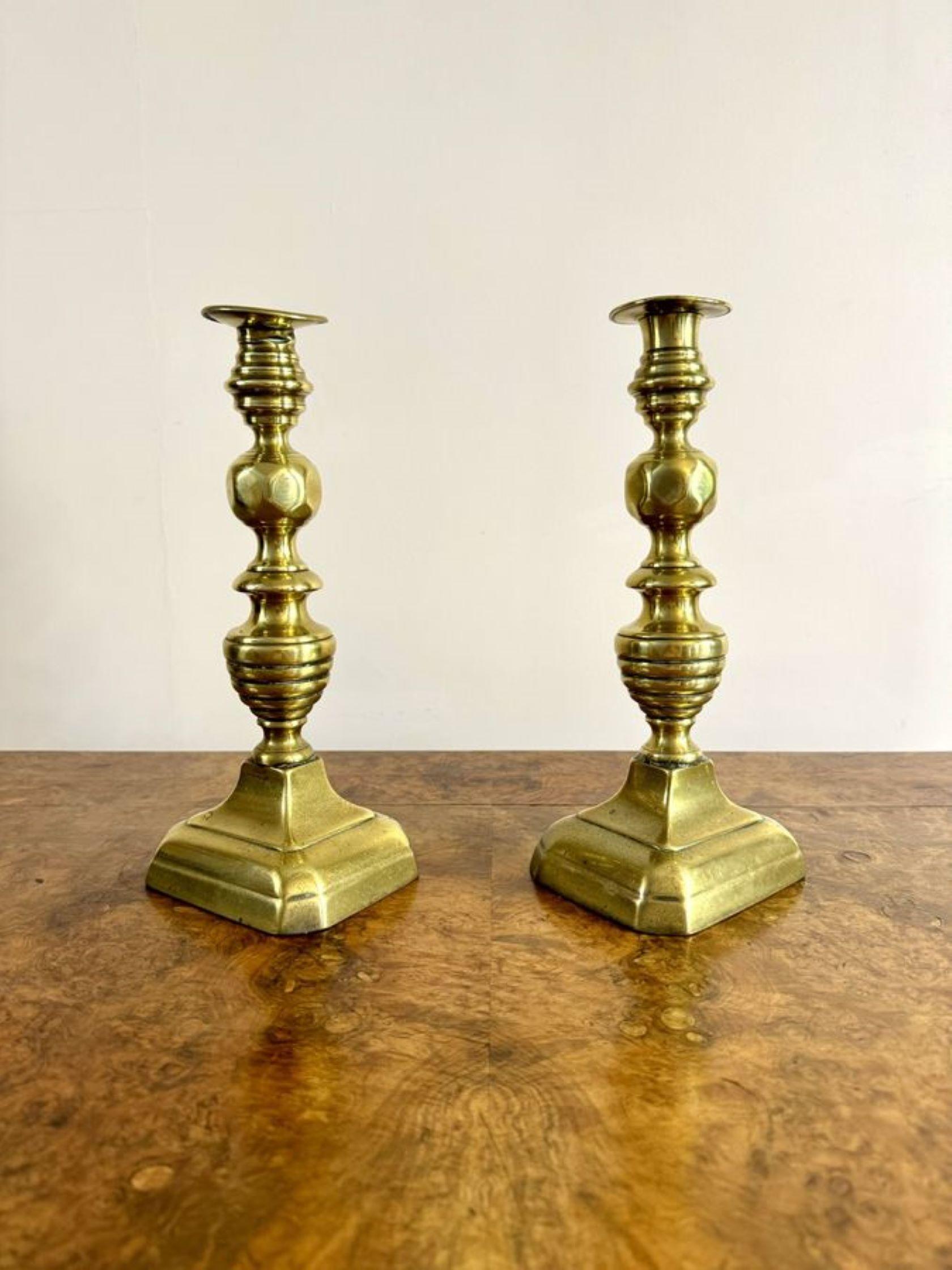 Quality large pair of antique Victorian brass candlesticks, having a large pair of Victorian brass candlesticks with turned shaped columns raised on rectangular shaped bases.

D. 1860