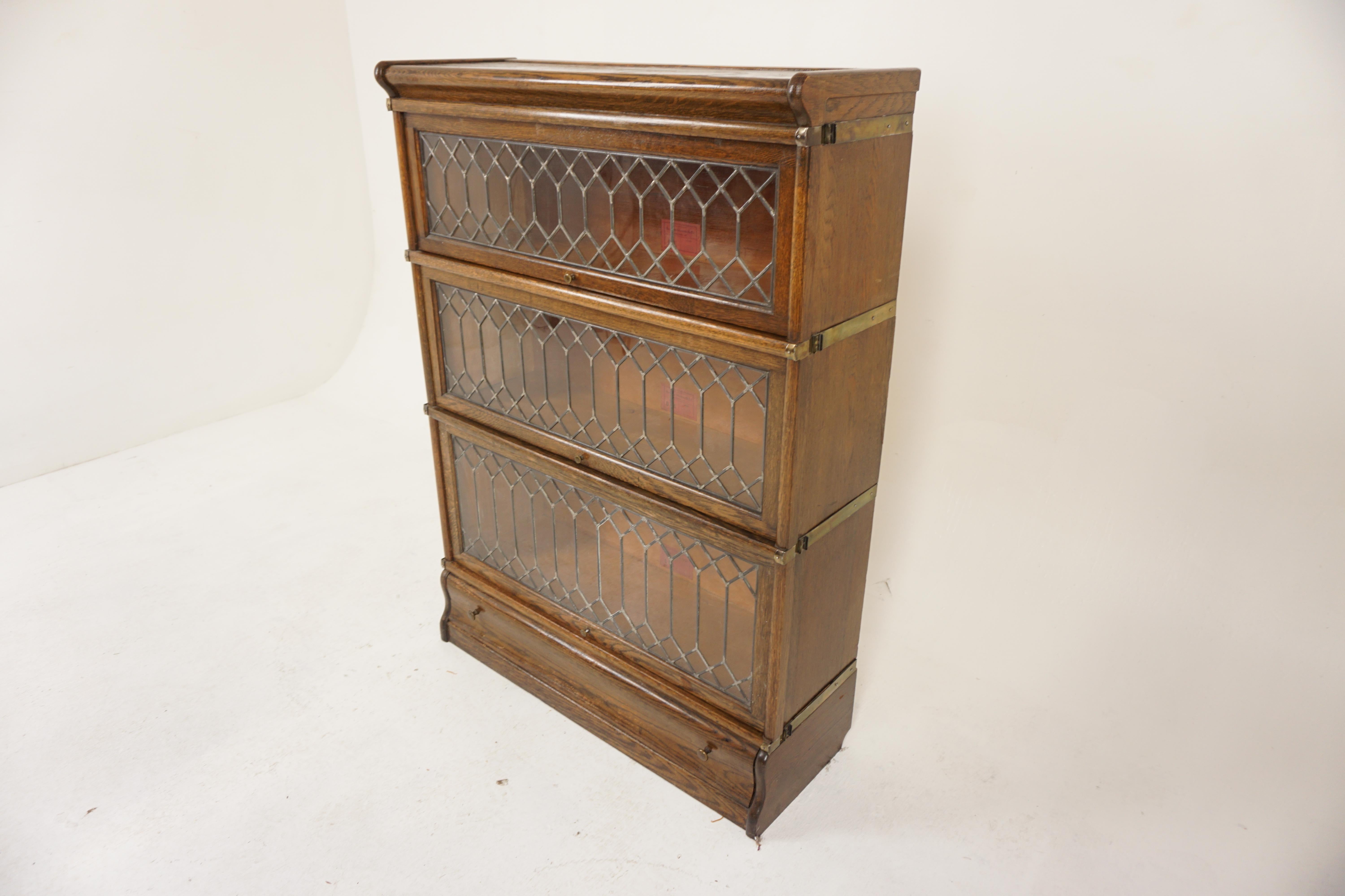 Quality Leaded Glass Oak Sectional Bookcase Globe Wernicke, Canada 1910, H1179

Solid Oak
Original finish
Oak top with low gallery on three sides
With three graduating doors with leaded glass and brass lifting knobs
The doors open and retract back