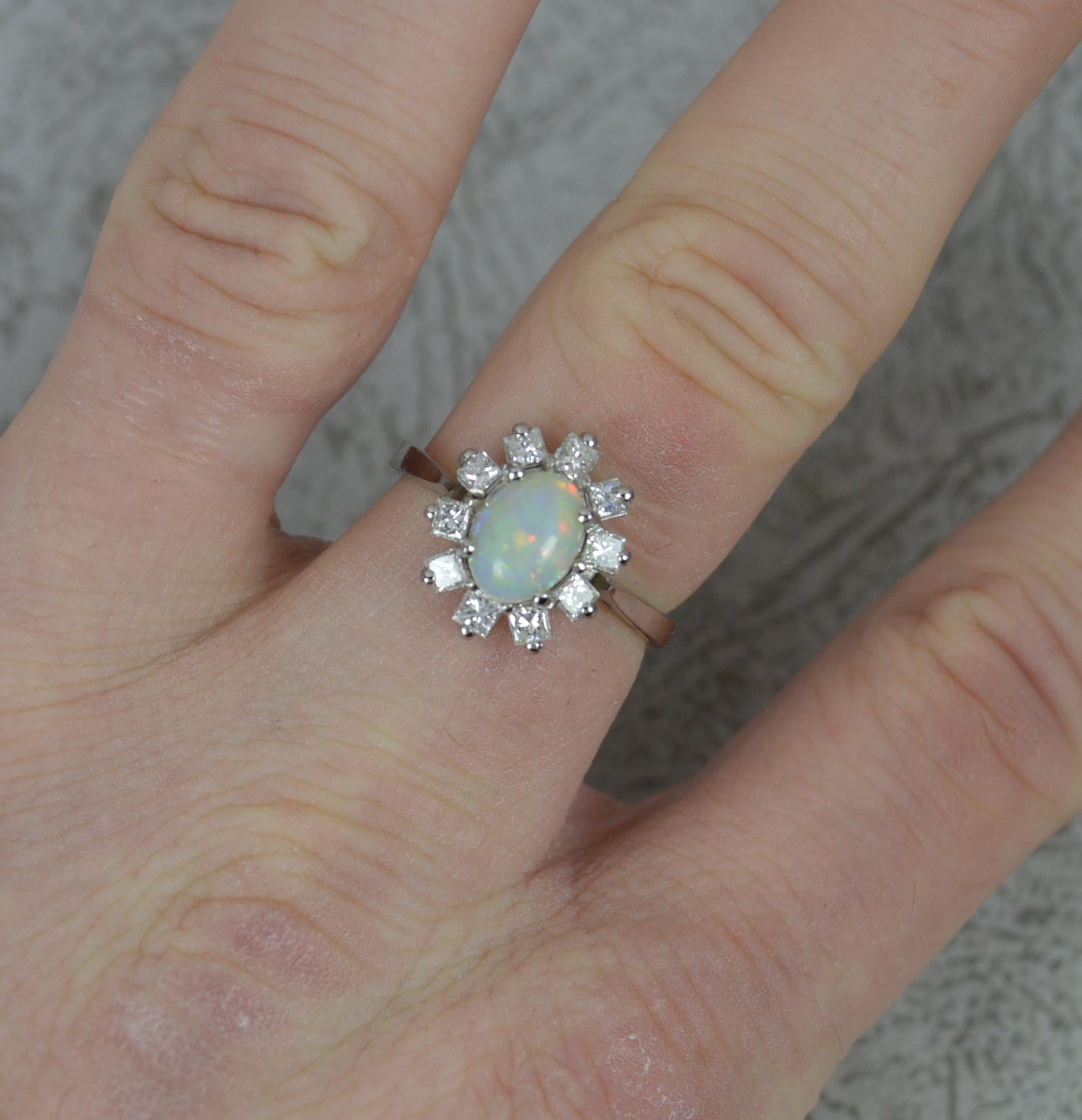 A superb Opal and Diamond cluster ring.
Designed with an oval shaped opal to centre, 6mm x 8mm. Surrounding are eight princess cut diamonds, vs clarity, f-g colour, 0.8cts total.
11mm x 13.5mm cluster head. Protruding 6.2mm off the