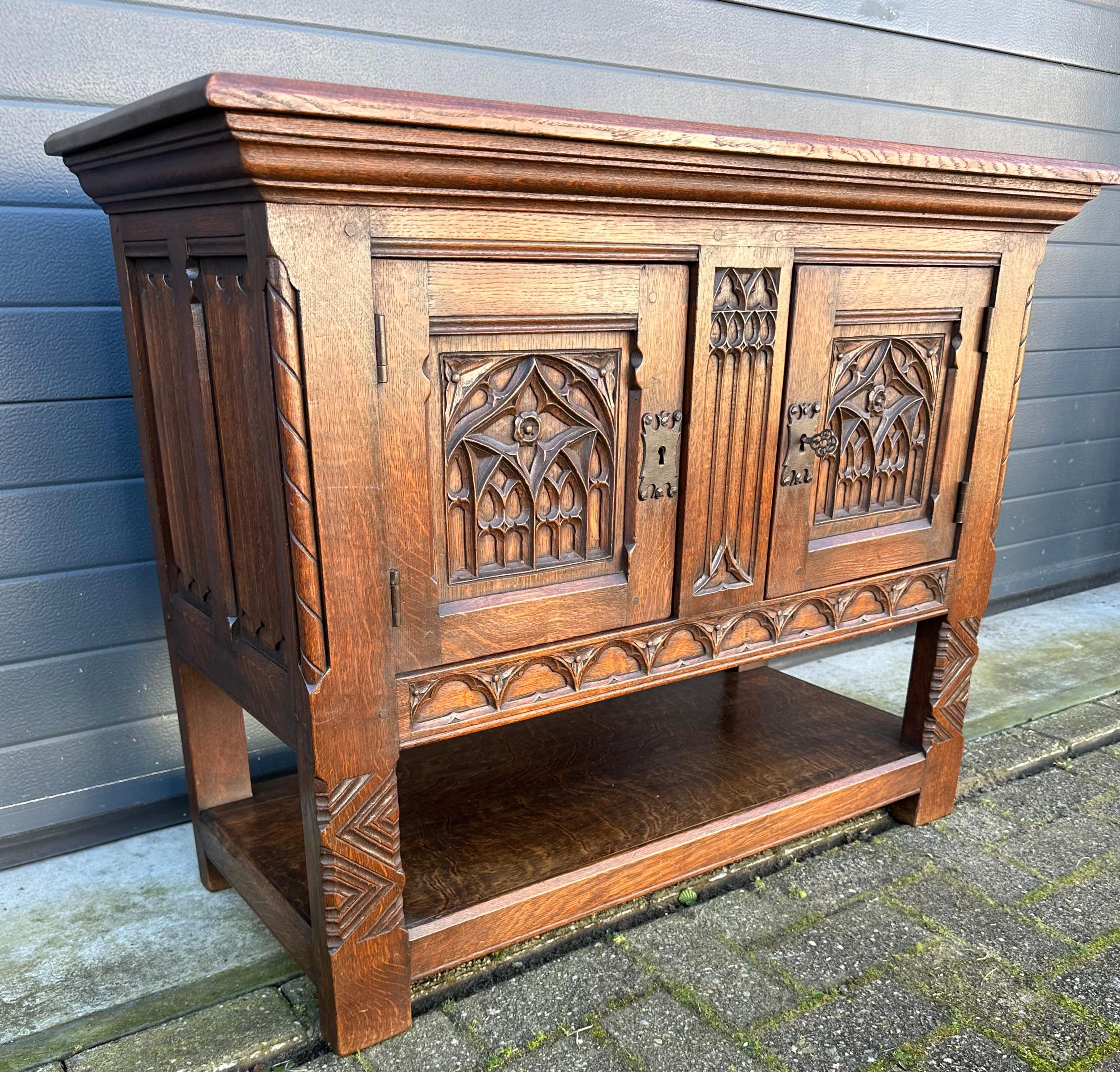 Early 1900s, solid oak and practical Gothic cabinet in amazing condition.

This handcrafted and very practical-in-size Gothic Revival cabinet can be used as a small credenza, as a sideboard, as a house-altar, as a side-table etc. Its marvelous look