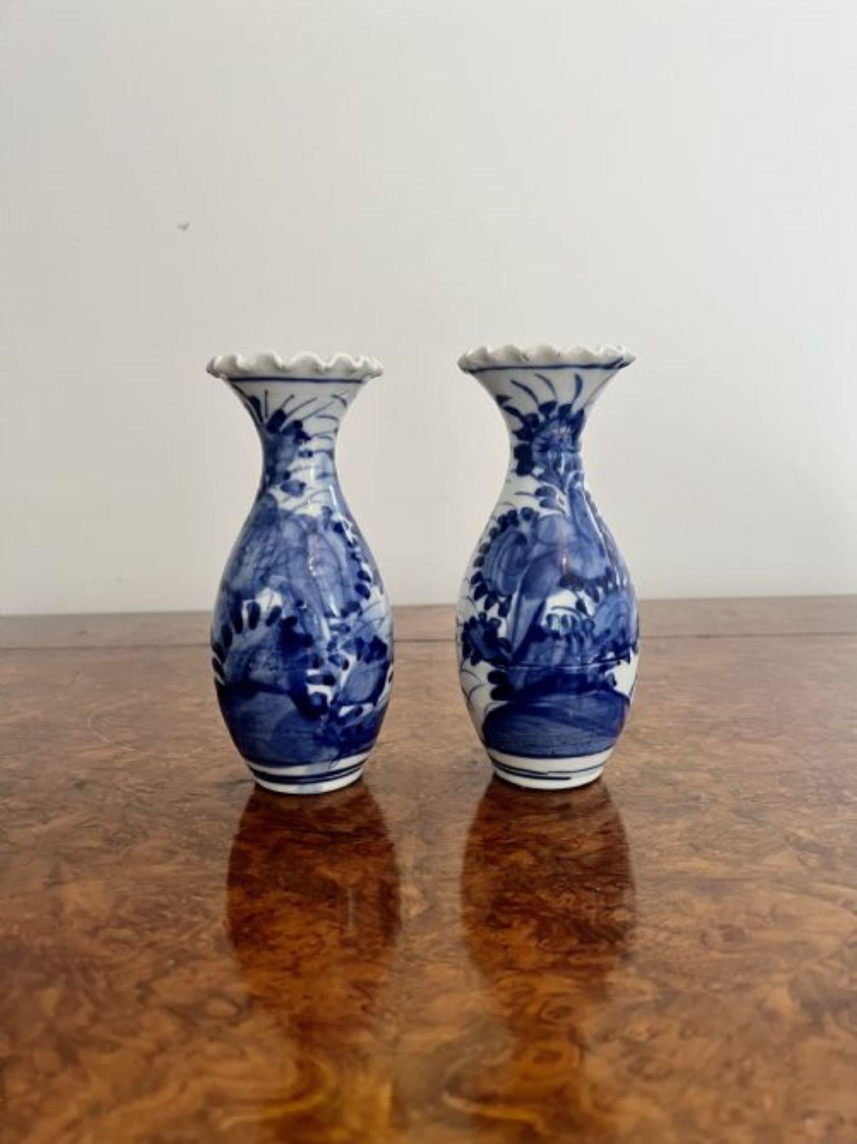 Quality pair of antique Japanese imari blue and white baluster vases having a quality pair of antique Japanese imari blue and white vases hand painted in stunning blue and white colours decorated with flowers, having a fluted wavy rim.