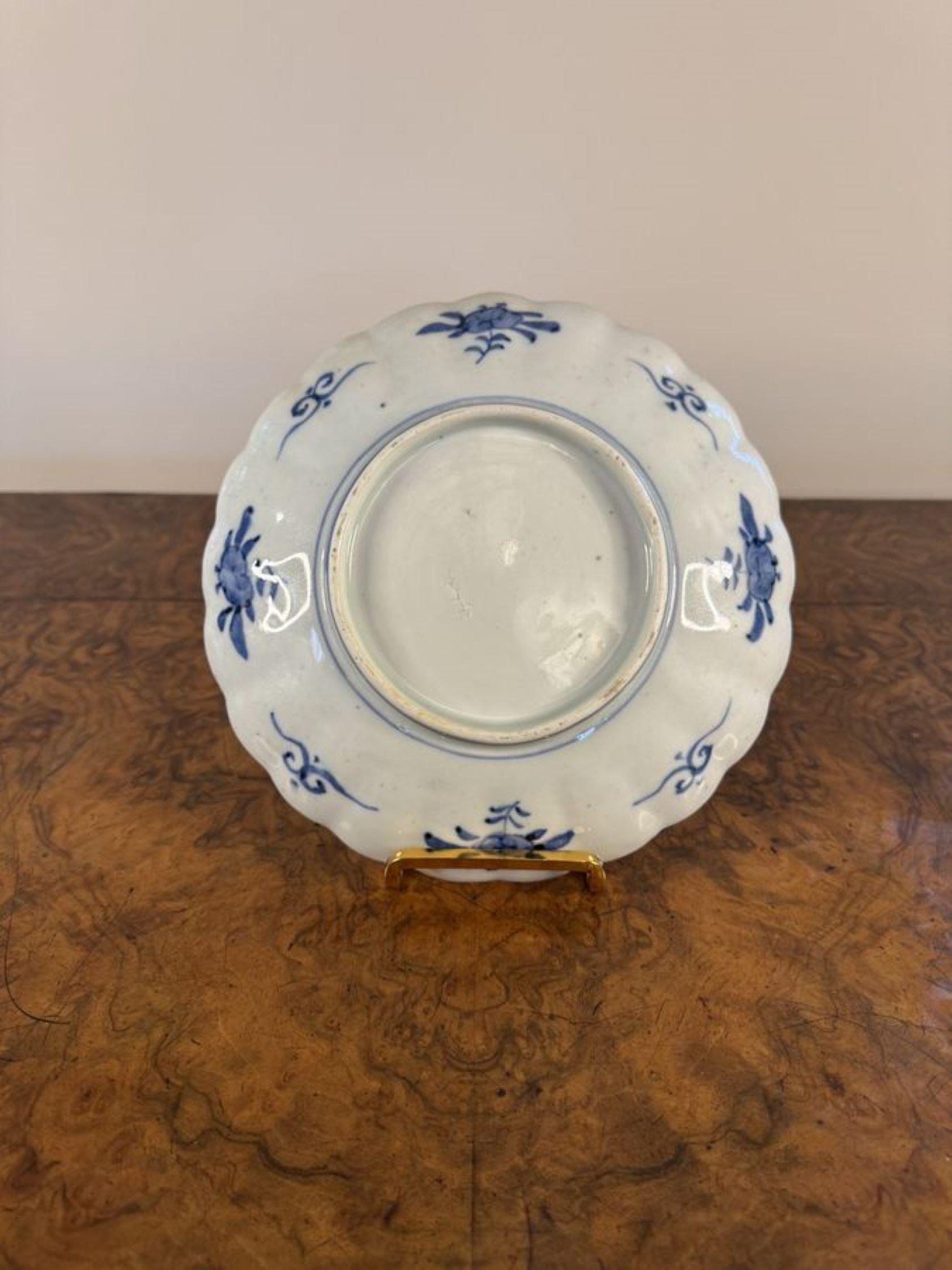 Hochwertiges Paar antiker japanischer Imari-Teller mit einem wellenförmigen Rand, verziert mit einem erhabenen Blumenmuster in der Mitte, umgeben von Blumen, Bäumen und Schriftrollen, handbemalt in wunderschönen roten, blauen, weißen, grünen und