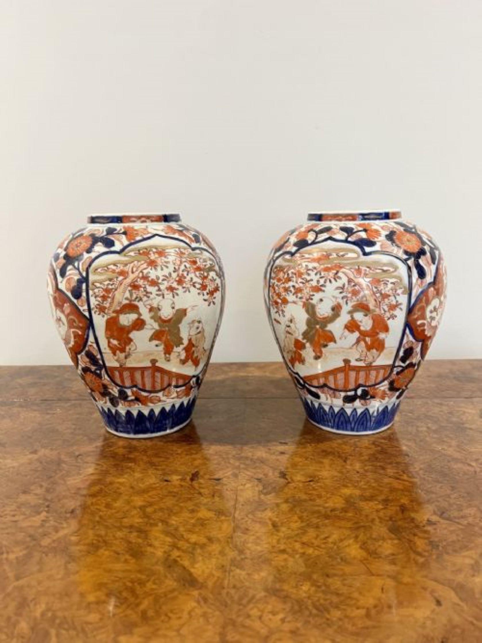 Quality pair of antique Japanese Imari vases having a pair of quality antique Japanese Imari vases with wonderful hand painted decoration with people, flowers, leaves, trees and scrolls in fantastic gold, red, orange, white and blue colours 