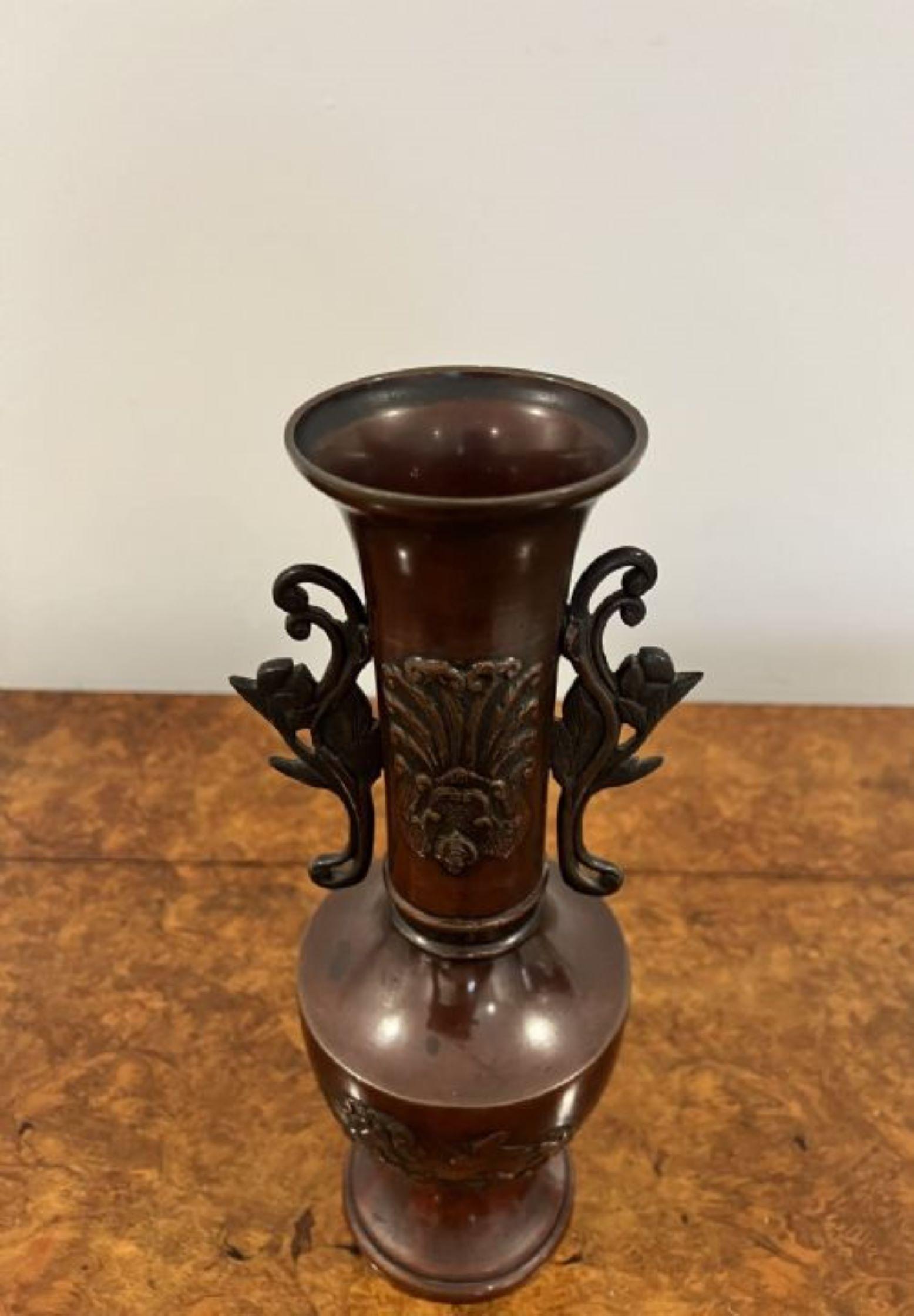 Quality pair of antique Japanese twin handle bronze vases having a quality pair of Japanese bronze vases decorated with flowers, birds and foliage with twin flower handles to the sides 
