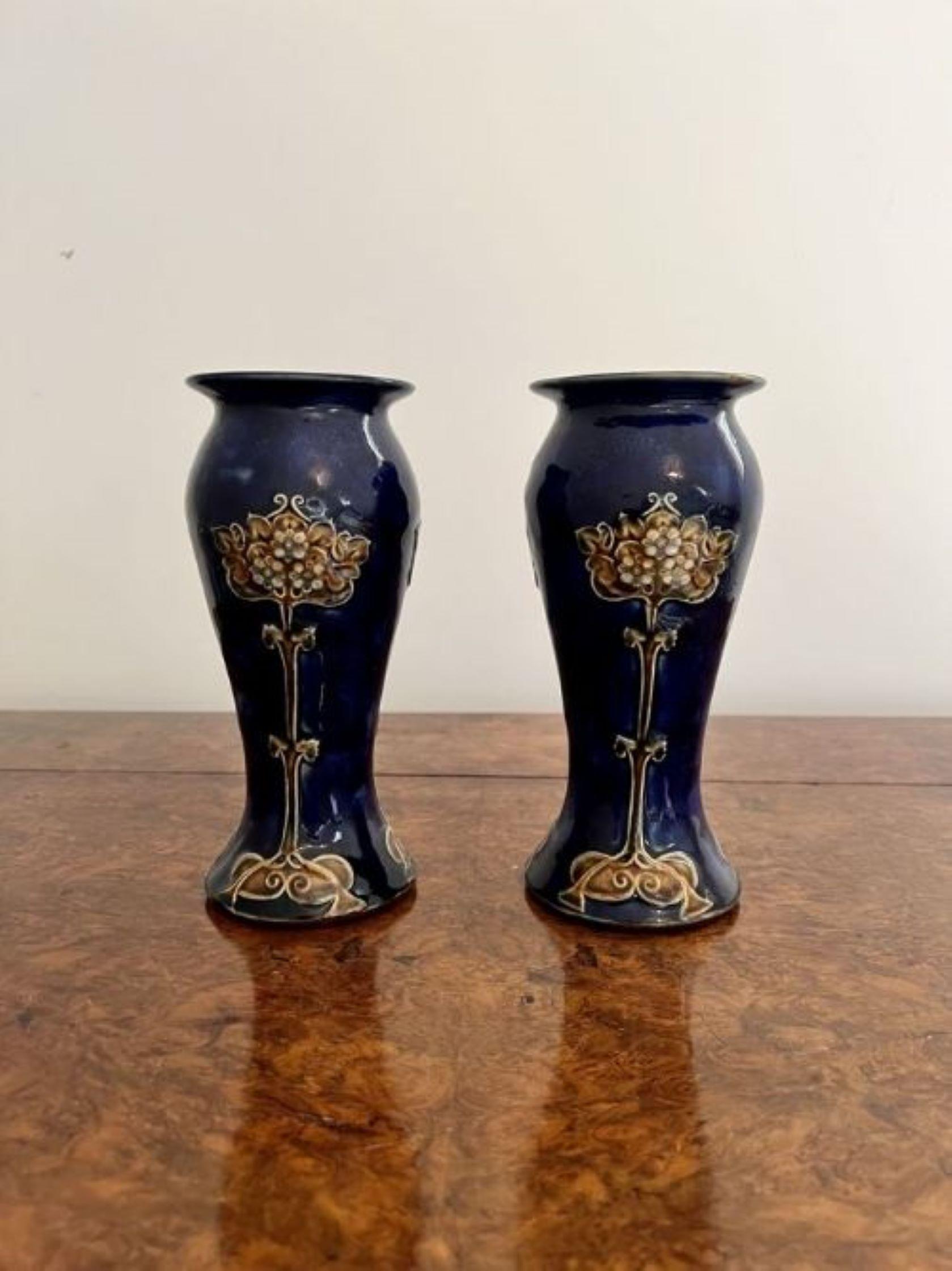 Quality pair of antique Royal Doulton Art Nouveau vases having a quality pair of antique Royal Doulton Art Nouveau vases, having a shaped body with a blue ground decorated with brown flowers stemming from the bottom of the vase with circular green