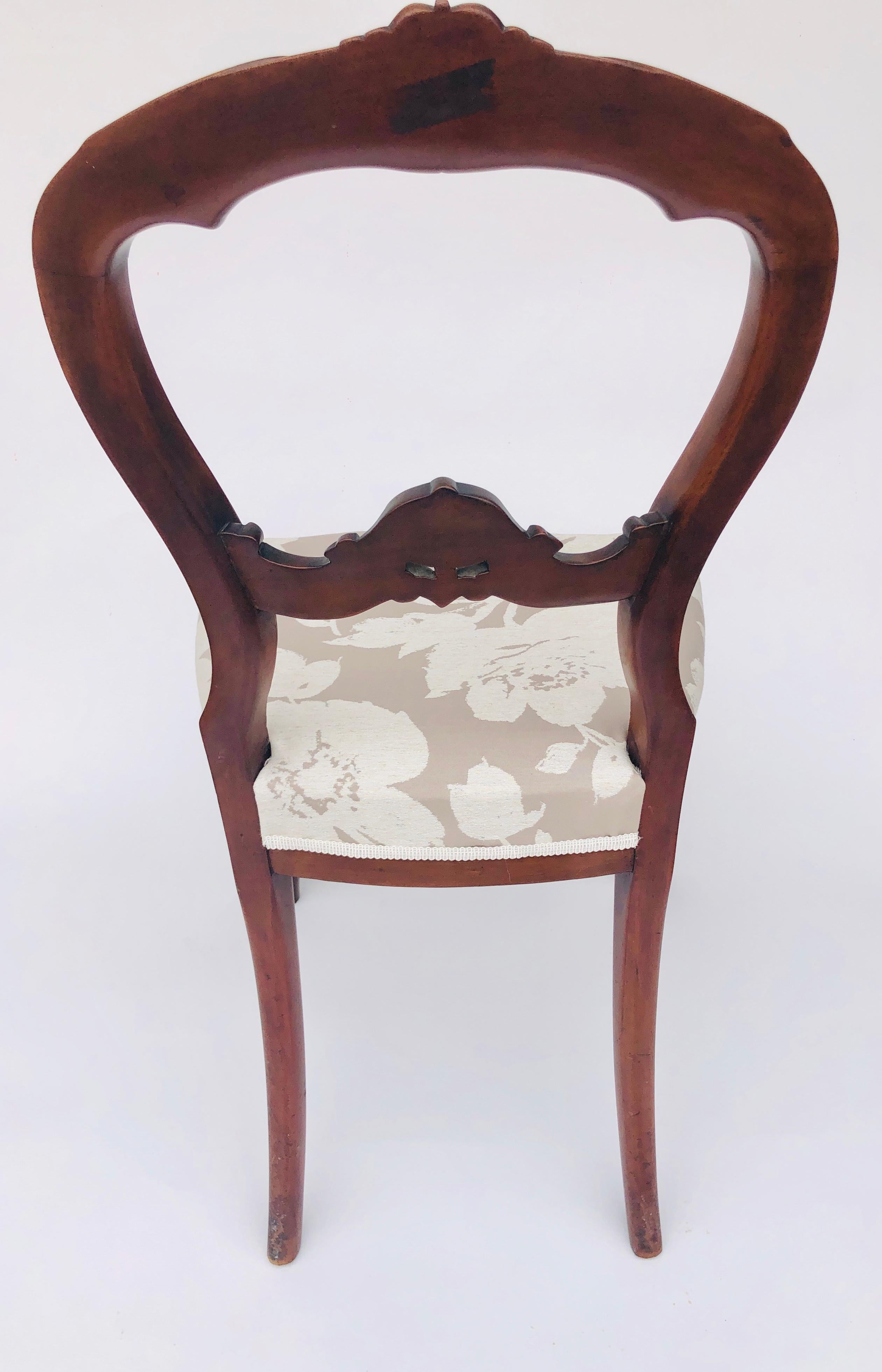 Quality pair of Victorian walnut cabriole legged side chairs. They boast a lovely shaped carved top rail with a carved shaped centre rail. Newly reupholstered in a quality fabric. Raised on elegant shaped cabriole legs to the front and outswept back
