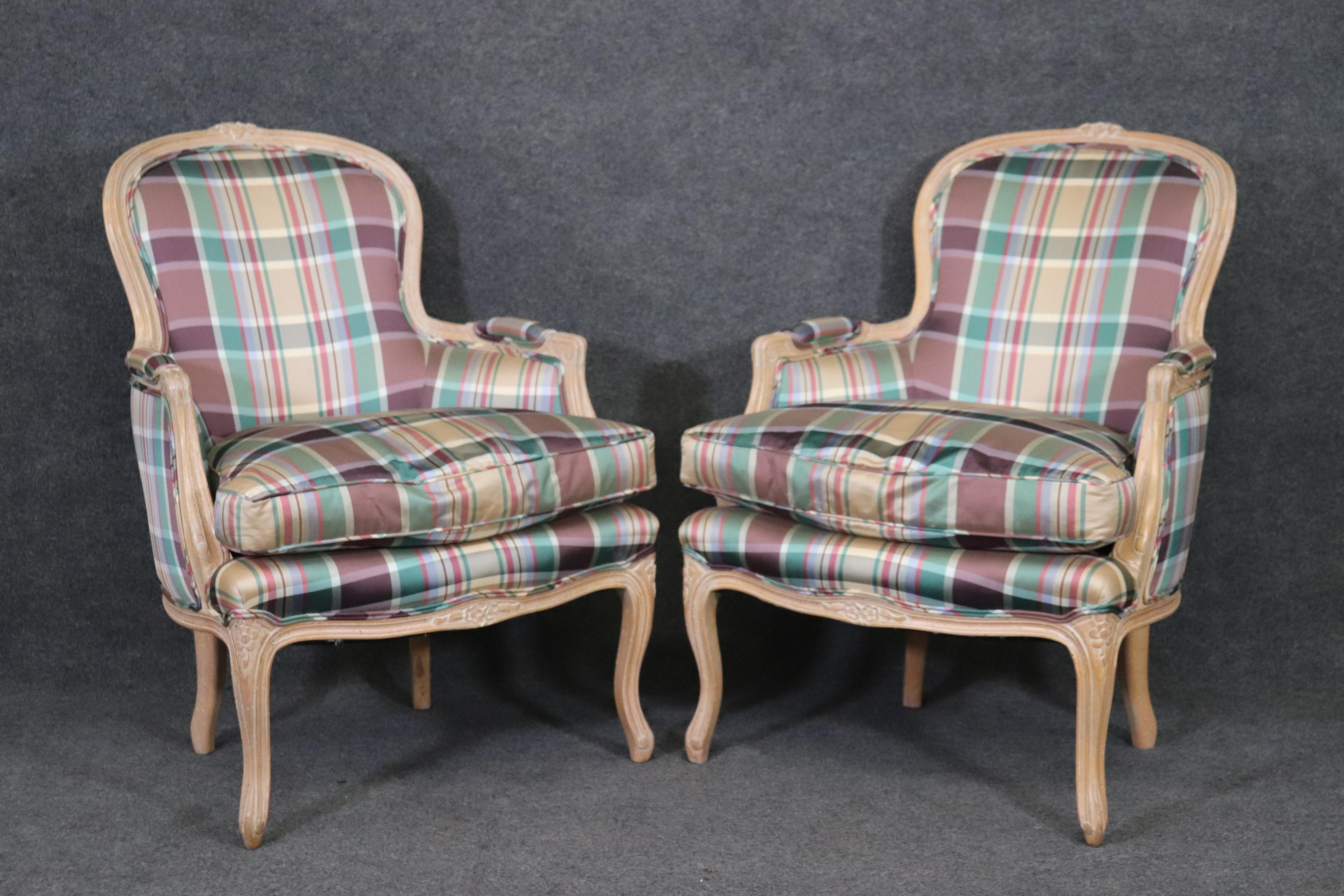 This is a gorgeous pair of French style American made bergeres. The chairs are in beautiful plaid upholstery and have a wonderful color combination that really works well in bright well-lit settings. The chairs are whitewashed beech frames and look