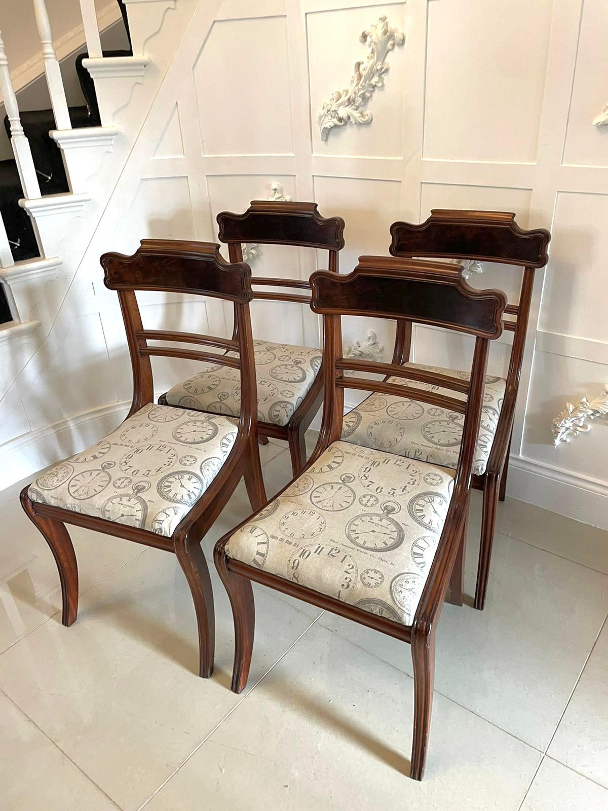 Quality set of four Regency antique mahogany dining chairs having a beautiful shaped flame mahogany top rail with a reeded edge and reeded centre rails. Newly reupholstered drop in seats in a stylish fabric and standing on reeded sabre legs to the