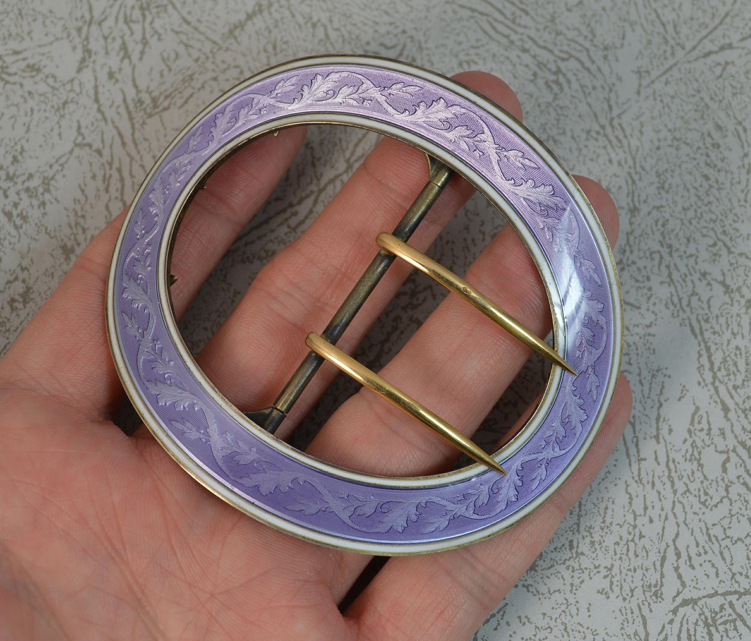 A superb buckle.
Sterling silver example.
Two 18 carat yellow gold prongs.
Designed with a fine lilac purple coloured guilloche enamel with white border.

Hallmarks ; full marks to reverse, French eagle to gold

Weight ; 54.4 grams all in

Size ;