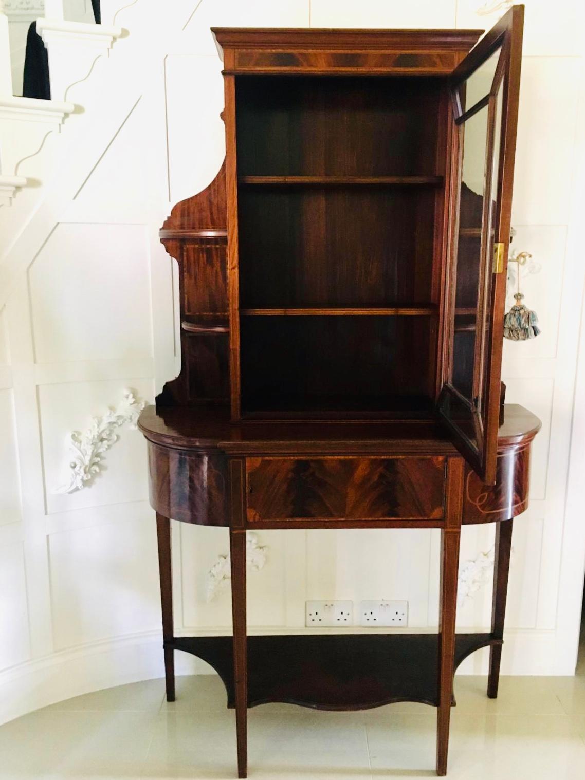 Quality unusual antique Edwardian mahogany and satinwood inlaid display cabinet. This attractive piece has a shaped cornice top section with one large astragal door opening to reveal two adjustable shelves, it is flanked by shaped side supports with