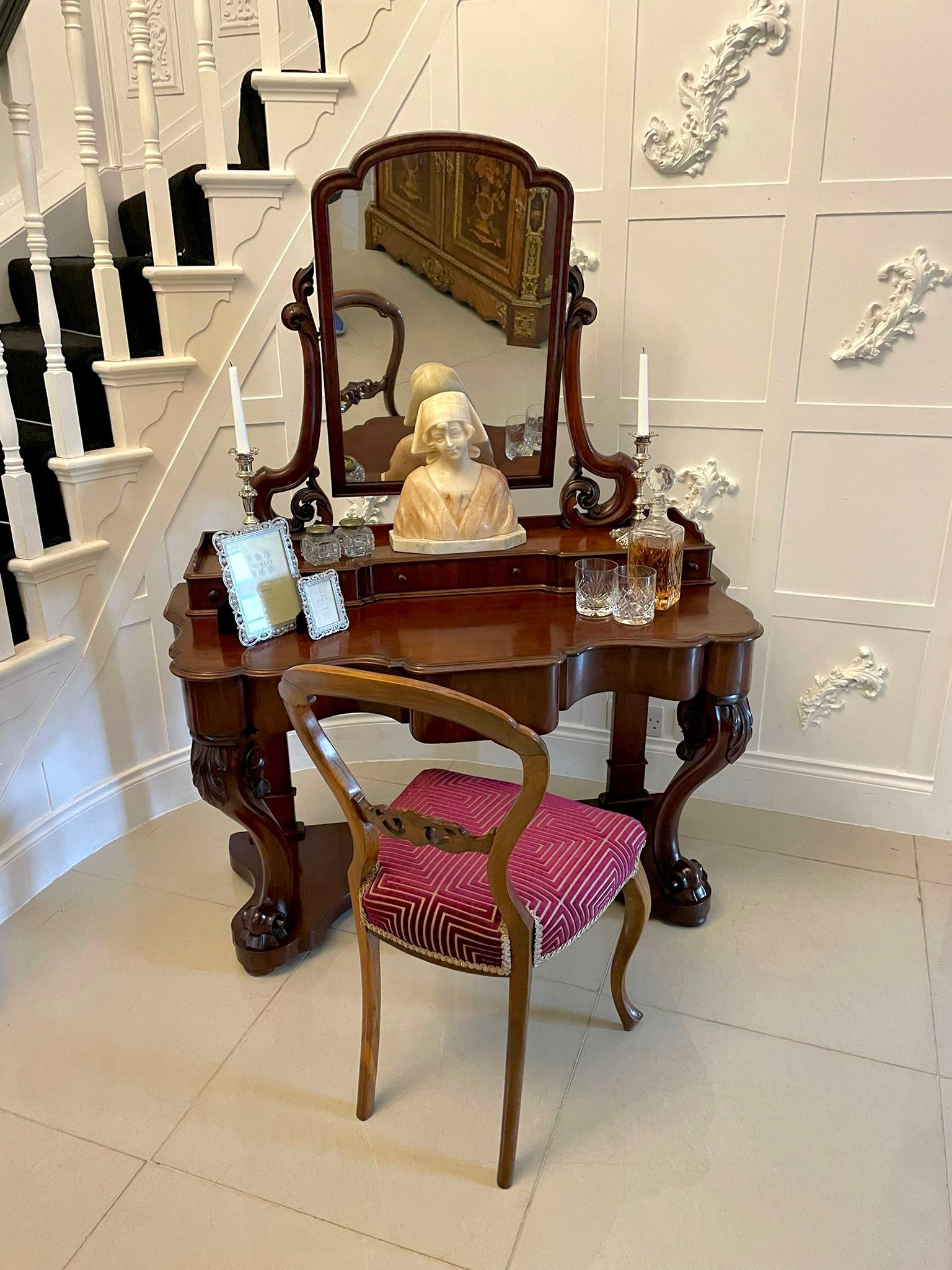 Quality Victorian antique carved mahogany dressing table having an attractive shaped upper section, tilting mirror with elegantly scrolled carved supports. It has three small attractive shaped drawers with original turned knobs. The lower section