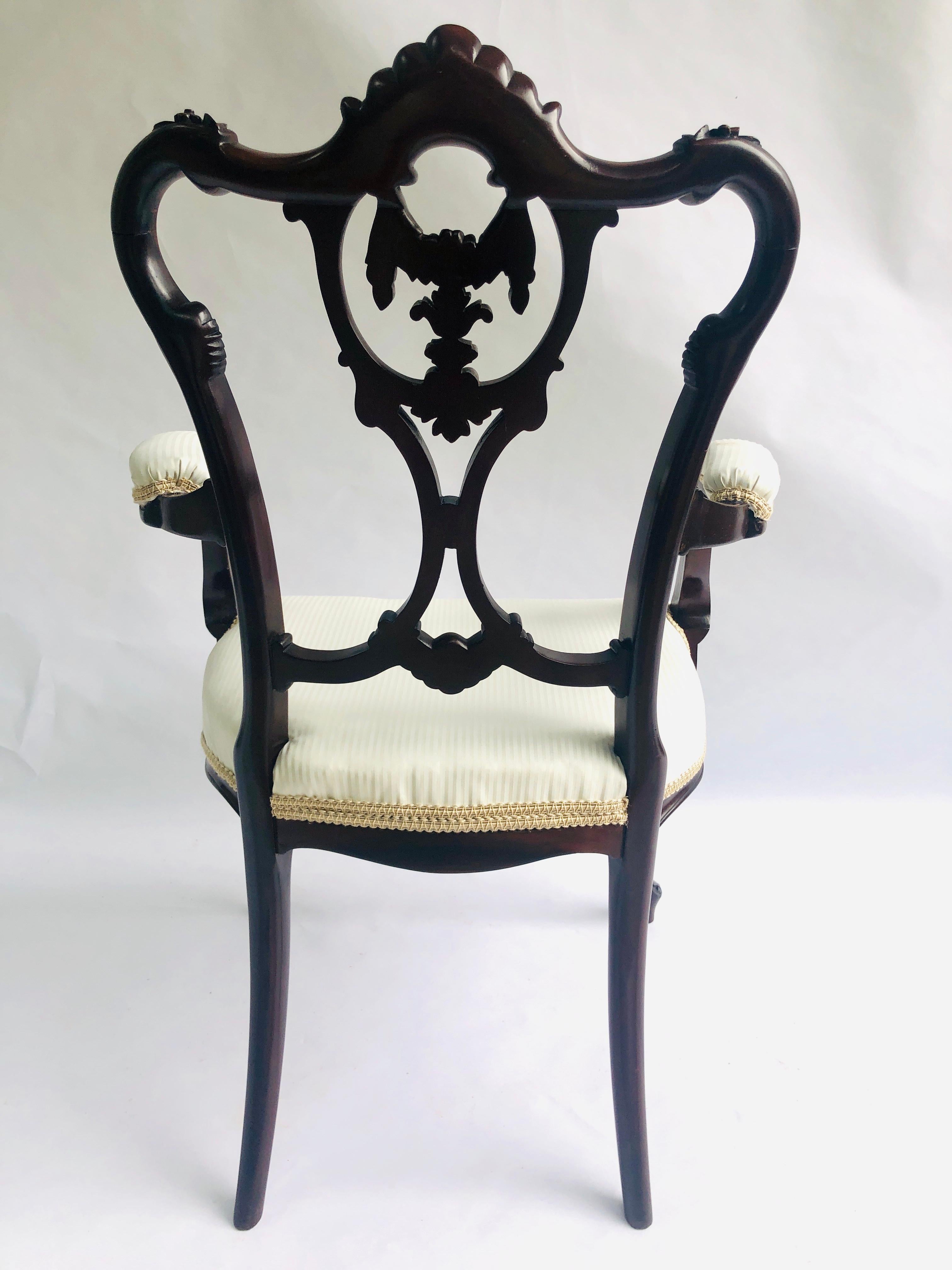 Une chaise ancienne de qualité en acajou sculpté de l'époque victorienne, avec une élégante rampe supérieure en forme et magnifiquement sculptée, et un dosseret central finement sculpté. Cette admirable pièce possède de magnifiques bras ouverts
