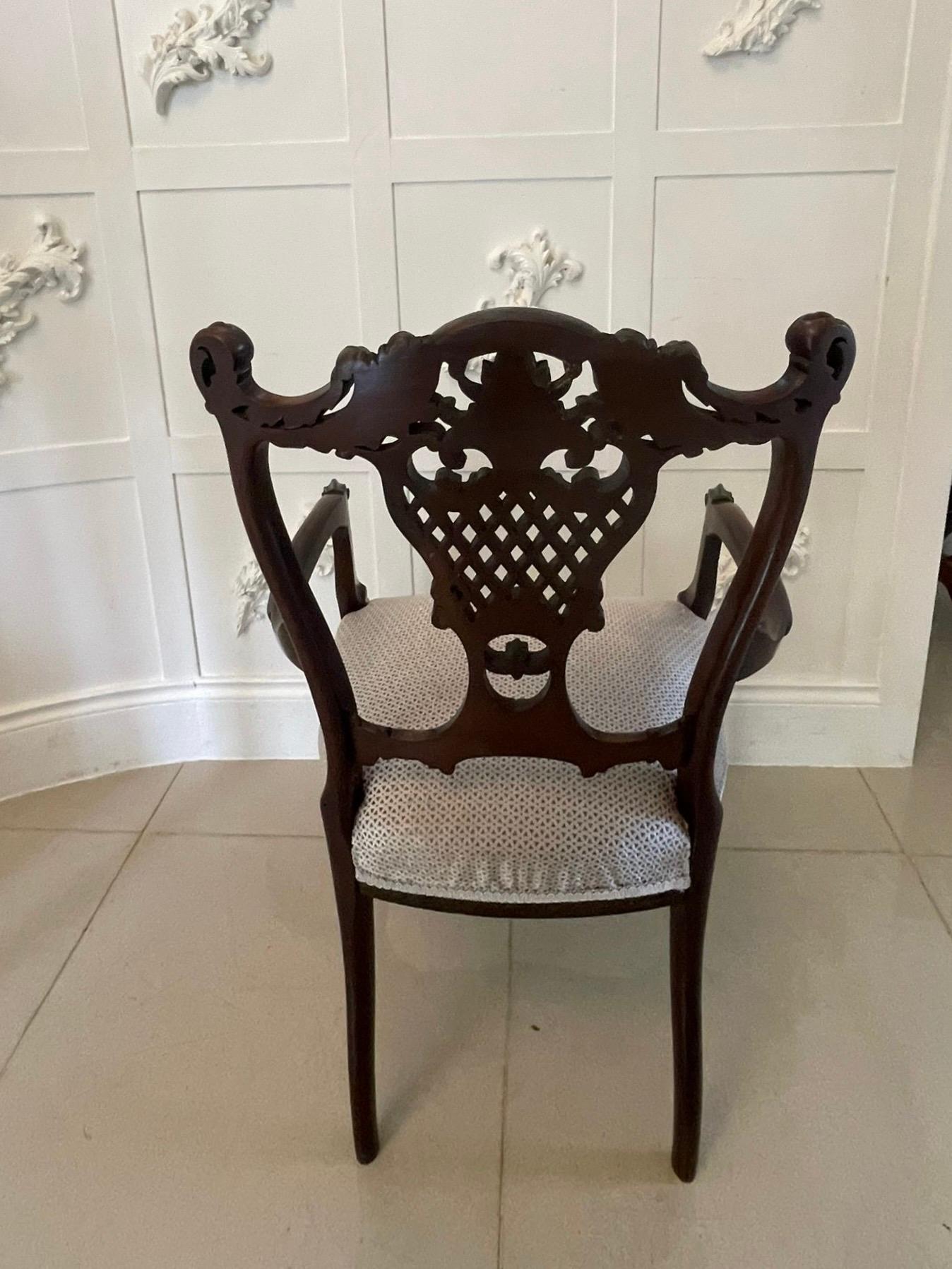 Sedia a gomito intagliata in mogano di qualità dell'epoca vittoriana con un elegante binario superiore sagomato e finemente intagliato e una stecca centrale finemente intagliata.  Questo ammirevole pezzo ha meravigliose braccia aperte intagliate e