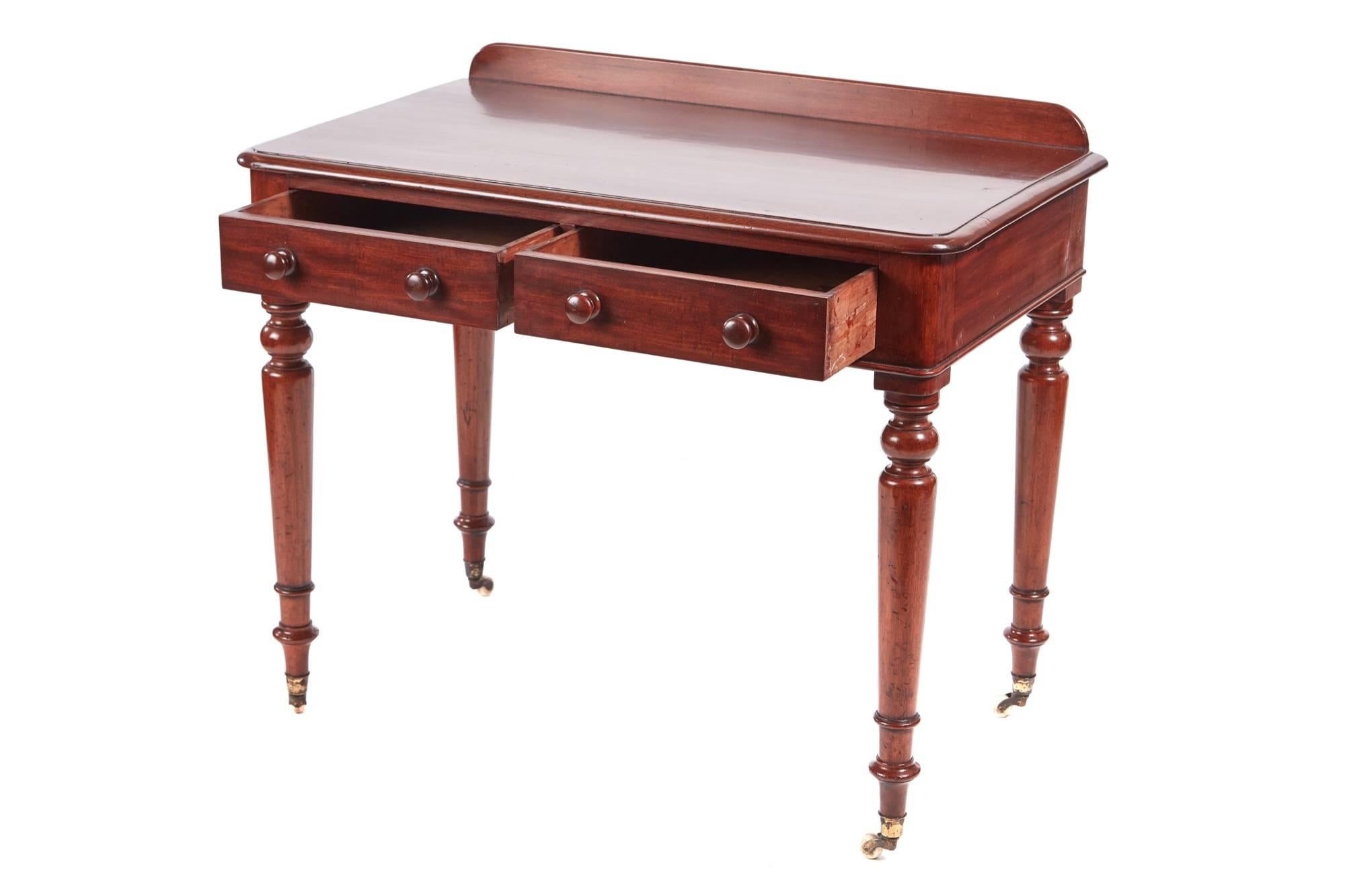 Quality Victorian mahogany side / writing table, having a low back, lovely mahogany top with a moulded edge, two drawers to the frieze with original turned mahogany knobs, standing on four turned legs with original castors.