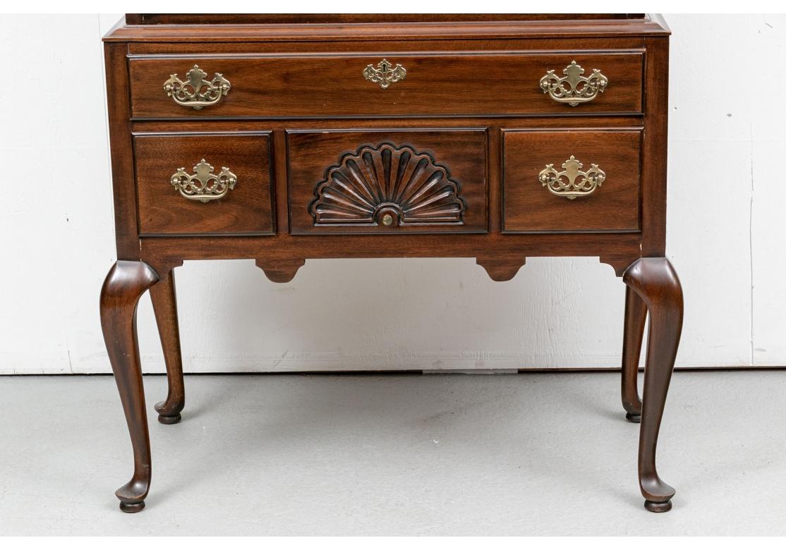 Finely crafted as Drexel is known for. The two part chest on chest with a broken bonnet top with urn finial. The top chest with three small drawers, the middle with a carved shell, over four graduated long drawers. The lower chest with one long over