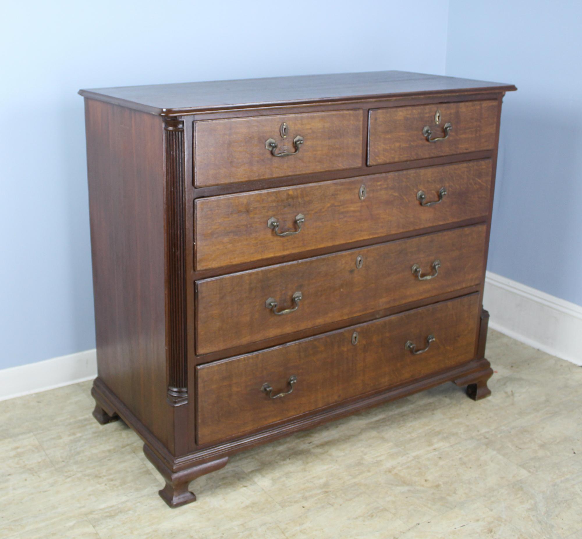 An early English chest of drawers with original handles and stylized ogee feet. Classic two-over-three construction and generously proportioned. Note the fine reeded quarter-columns.