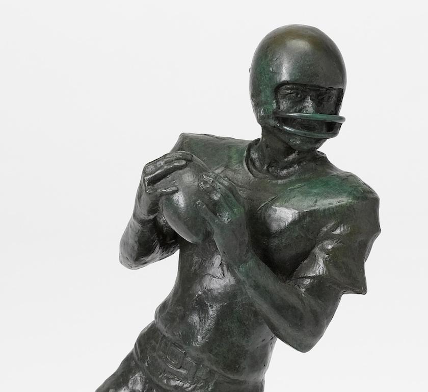 A striking bronze of a quarterback dropping back and looking downfield in the hope of completing a forward pass. Bronze is by American 20th century sculptor and painter L. Lumetta. 
