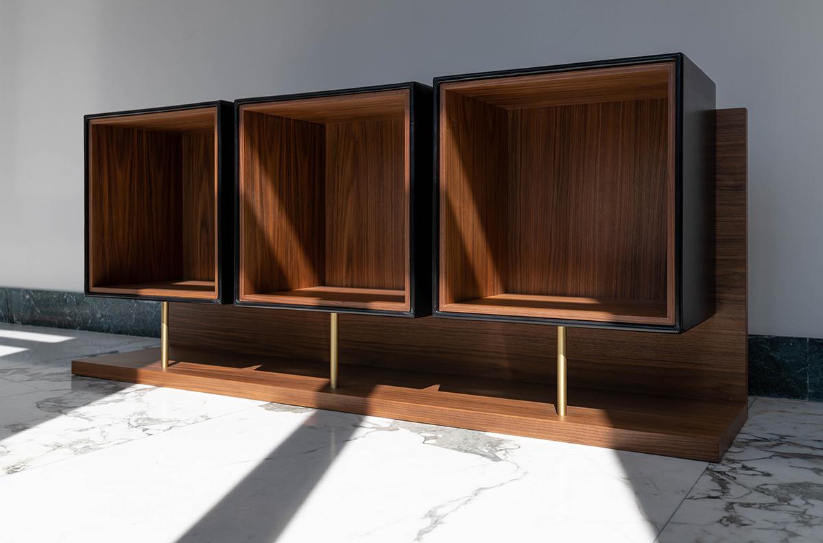 Quartet uses a single L-shaped support to bear the three cubic leather modules, forming the back and base sections, both of which reveal the longitudinally arranged long wood grain of Canaletto walnut, making this an object to display at the centre