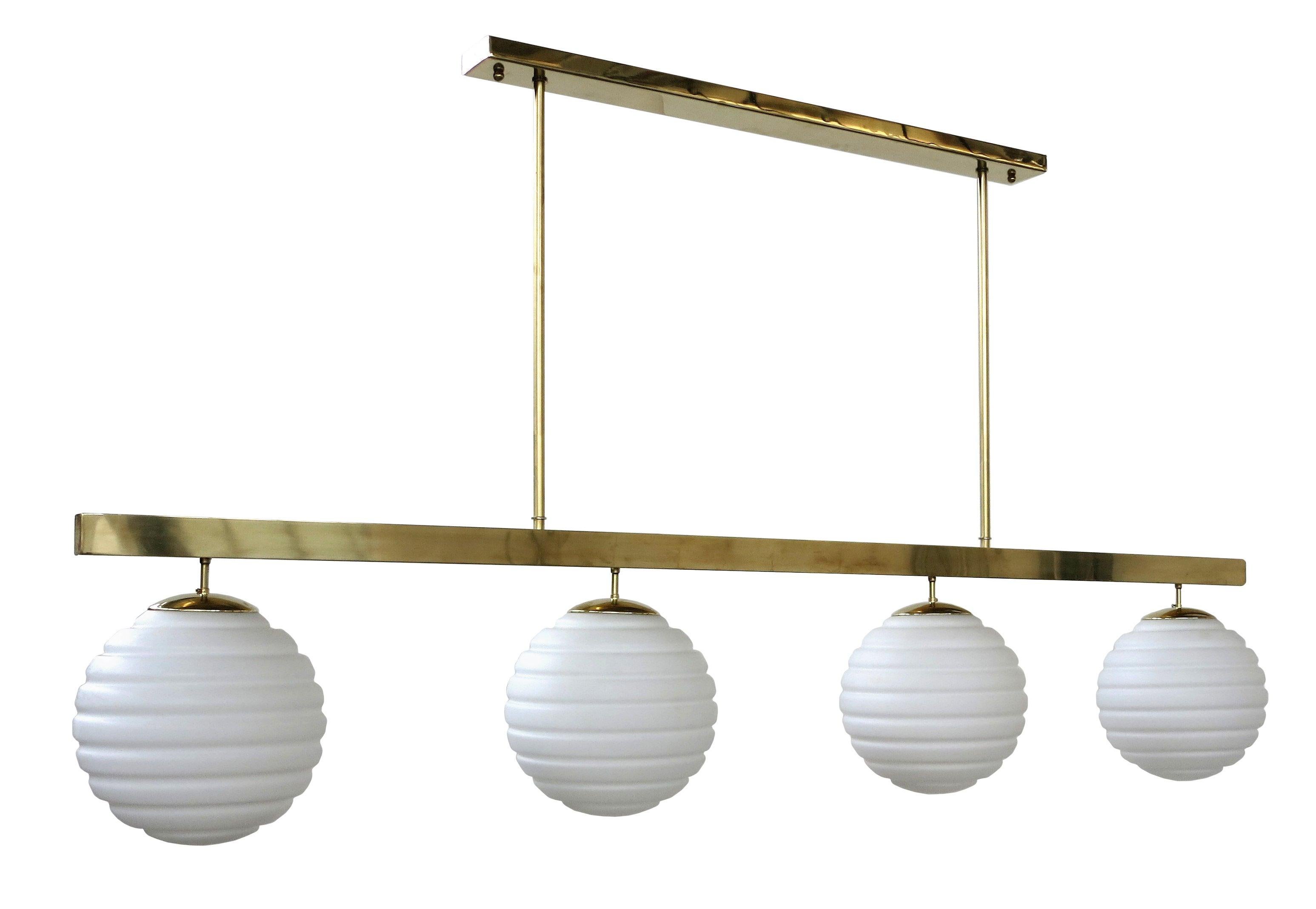 Italian pendant chandelier shown in white ribbed Murano glass globes, mounted on polished brass frame / Designed by Fabio Bergomi for Fabio Ltd / Made in Italy
4 lights / E26 or E27 type / max 40W each
Measures: Height 41.5 inches including rods and