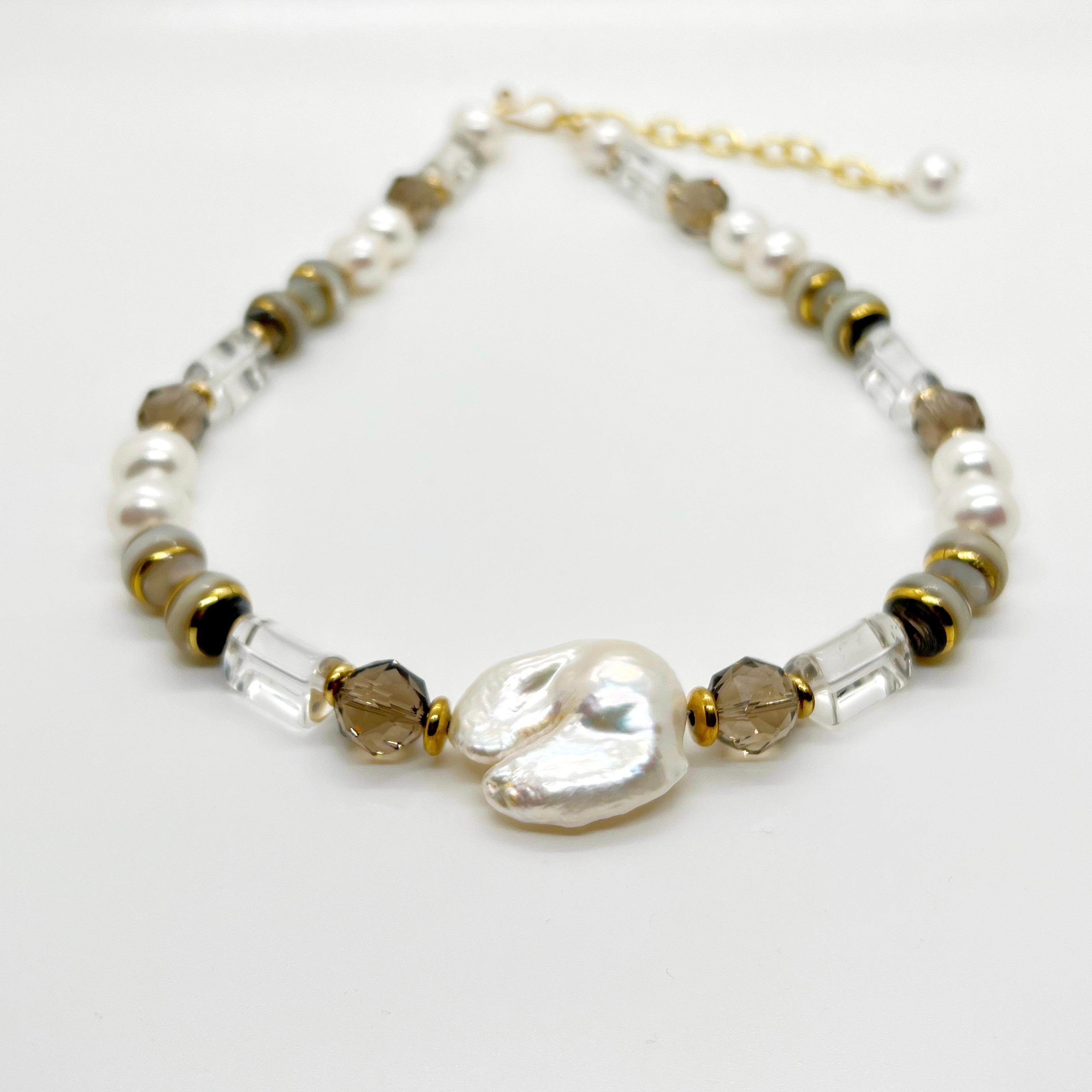 The Collette necklace is a medley of clear and smokey quartz, with freshwater pearls and artisan made banded beads that are made from mother of pearl and abalone shells. This necklace is 18 inches and can be extended up to 20 inches.

Please note
