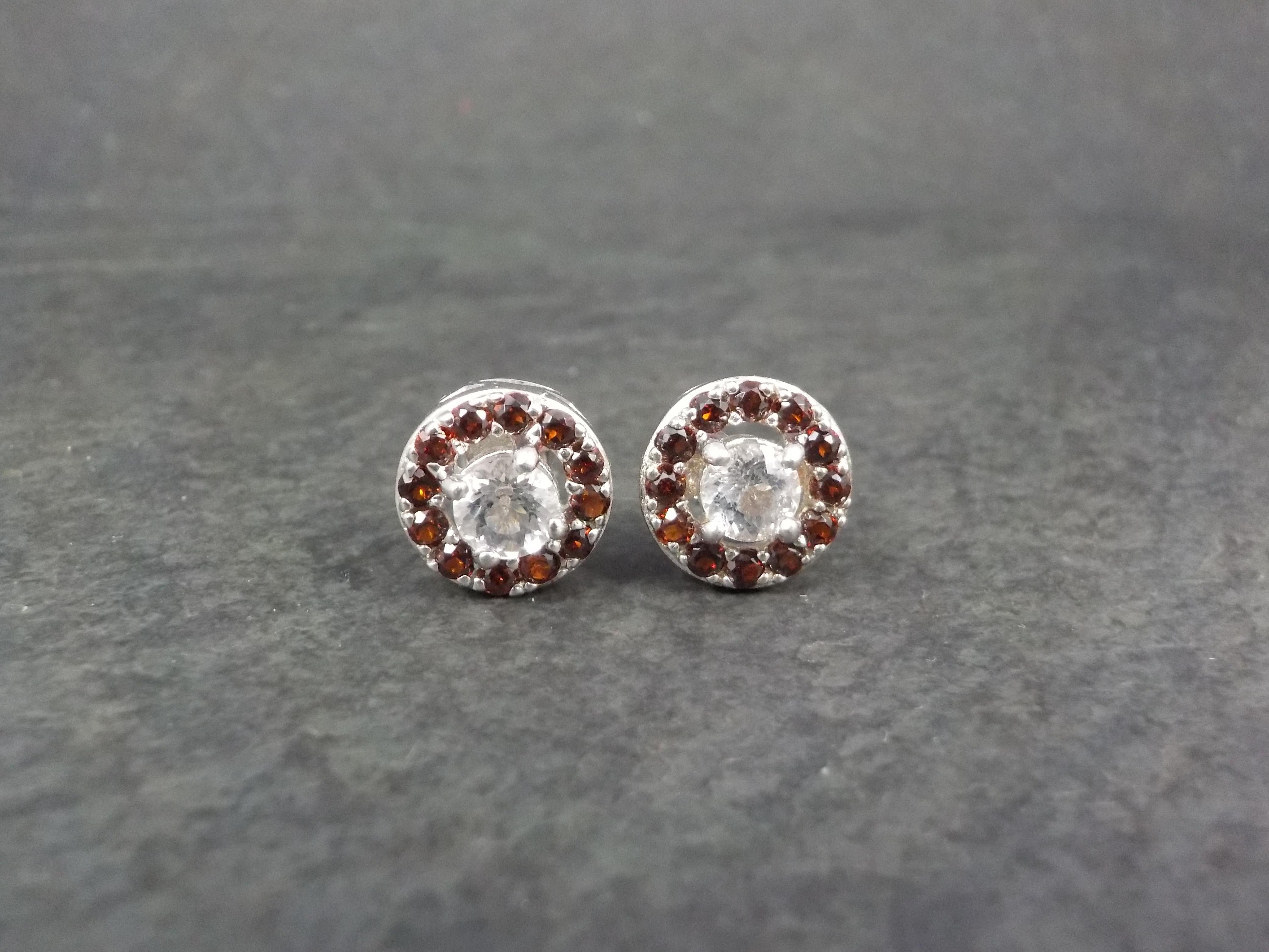 These gorgeous stud earrings are sterling silver.
They feature 5mm round, diamond cut quartz accented by a halo of garnets.
Measurements: 7/16 of an inch
Weight: 3.5 grams
Condition: New old stock