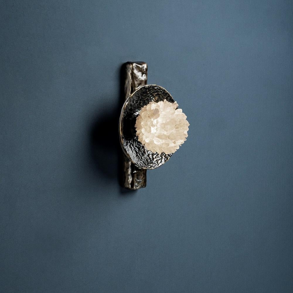Quartz and Bronze Wall Light I by Aver
Dimensions: W 18 x D 16 x H 27 cm
Materials: Natural rocks, high-quality cut crystals, jewelry chains, hand blown glass, other.
Also Available: Matte Black, Rustic Silver, Oxidized Graphite, and Rustic