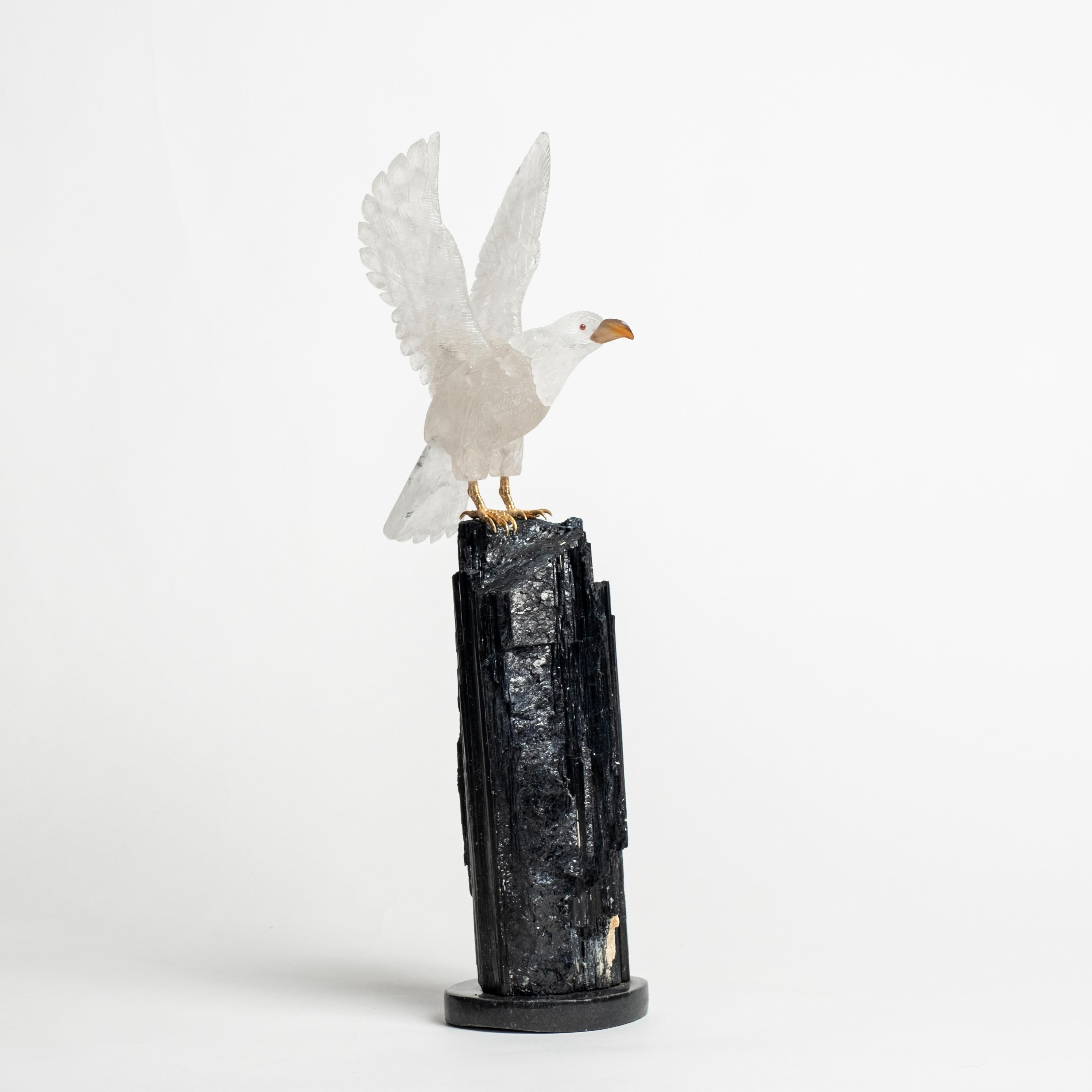 Escultura de águila de cuarzo tallada a mano sobre base de turmalina negra. 
