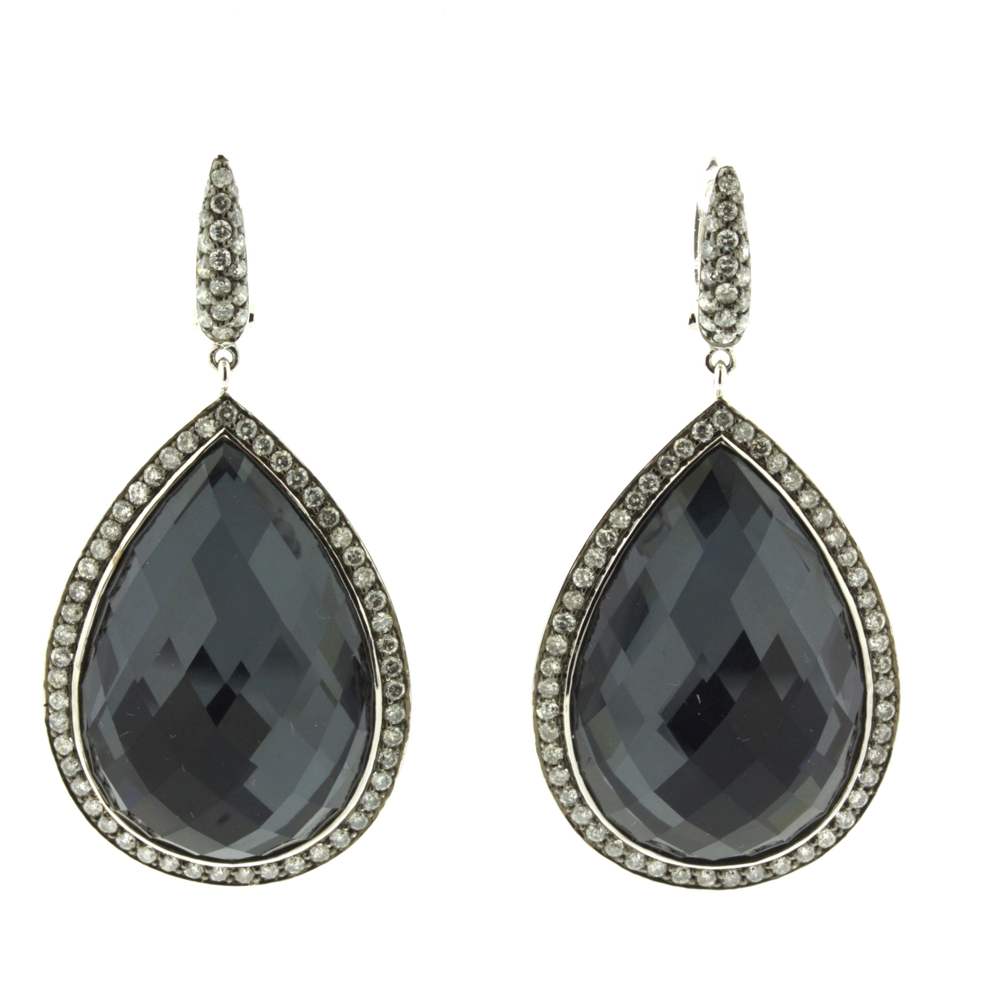 A modern and unique pair of drop earrings made in 18k white gold. They feature rose-cut smoky quartz with a thin slice of hematite set under each earring. This gives the quartz a deeper rich metallic color that shines bright in the light. They weigh